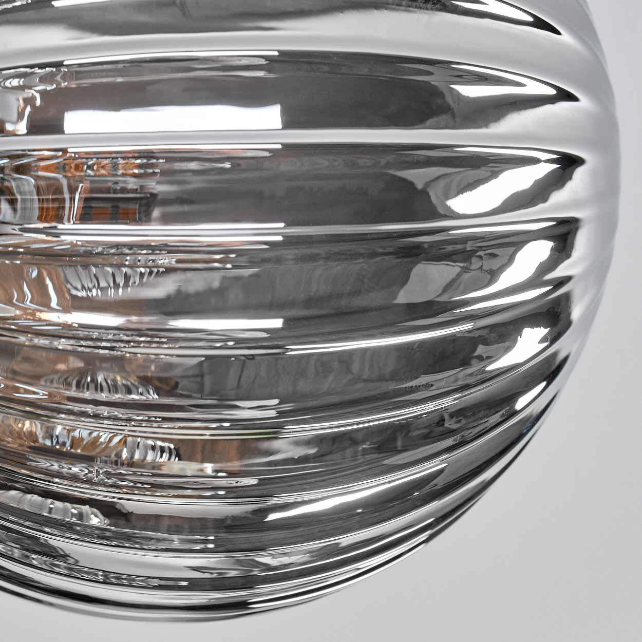 Nahaufnahme einer strukturierten Glaskugel mit einer reflektierenden, gerippten Oberfläche.