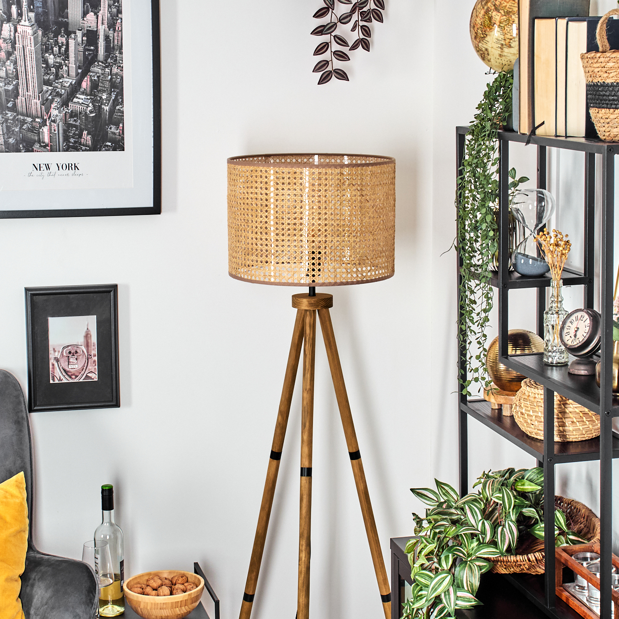 Stehlampe aus Holz mit gewebtem Lampenschirm, neben einem Regal und Dekoration.