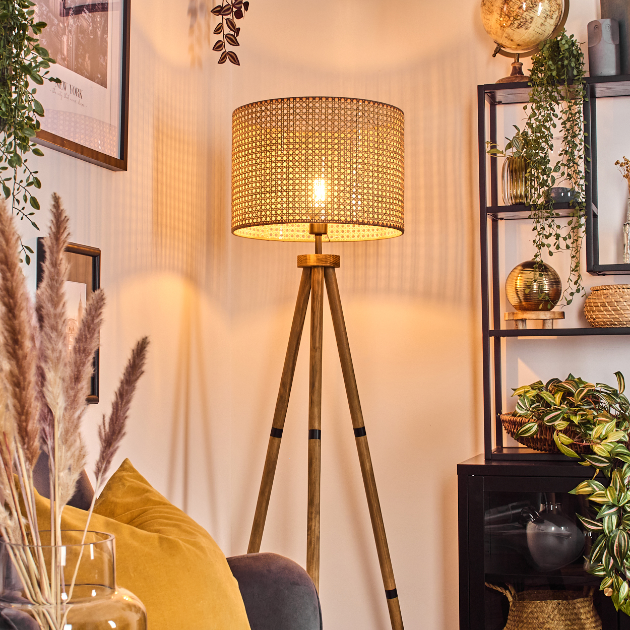 Eine beleuchtete Lampe mit einem Korbschirm steht in einem Wohnzimmer mit Pflanzen und einem Globus.