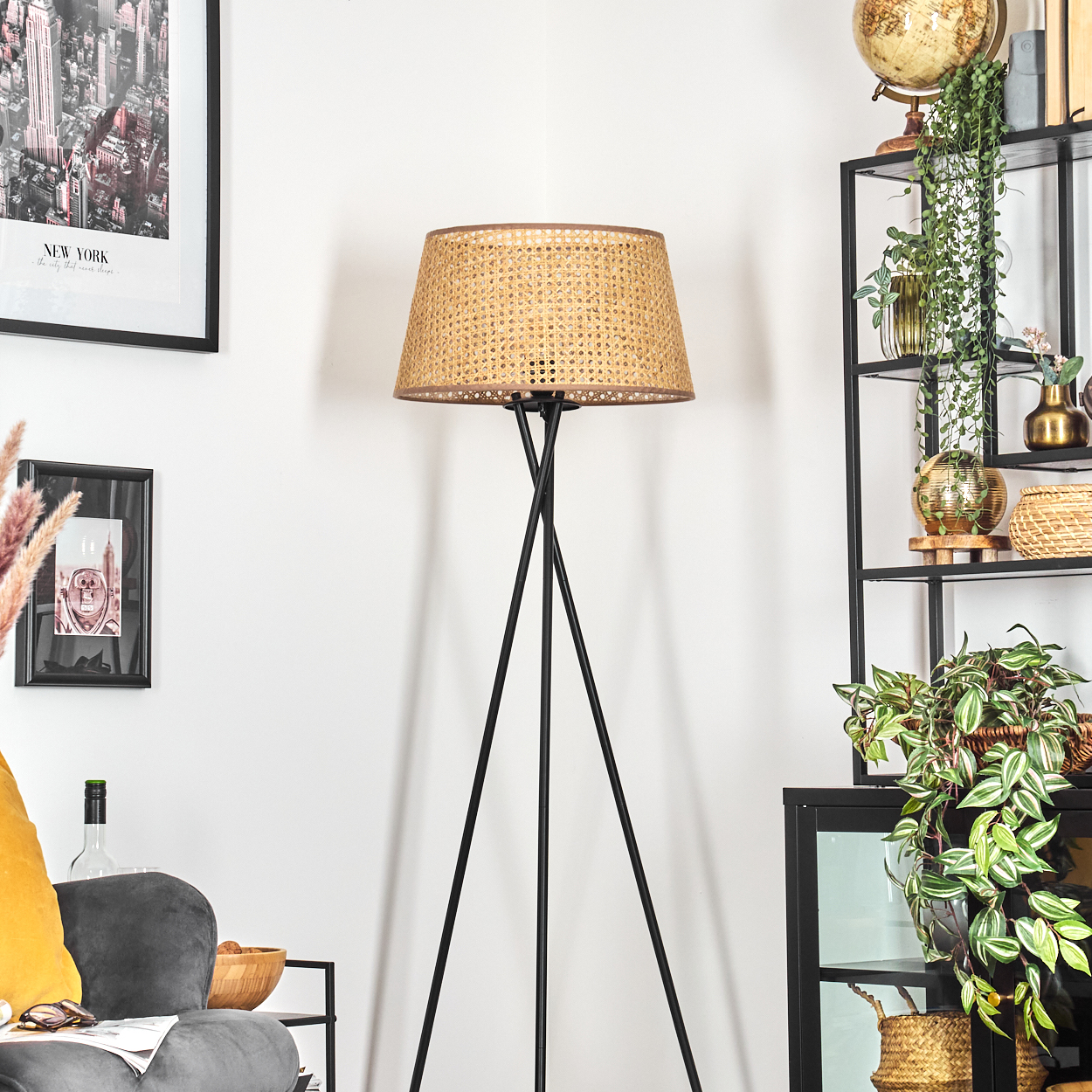 Stehlampe mit gewebtem Schirm, schwarzem Rahmen, New York-Druck, Pflanzen und Deko.