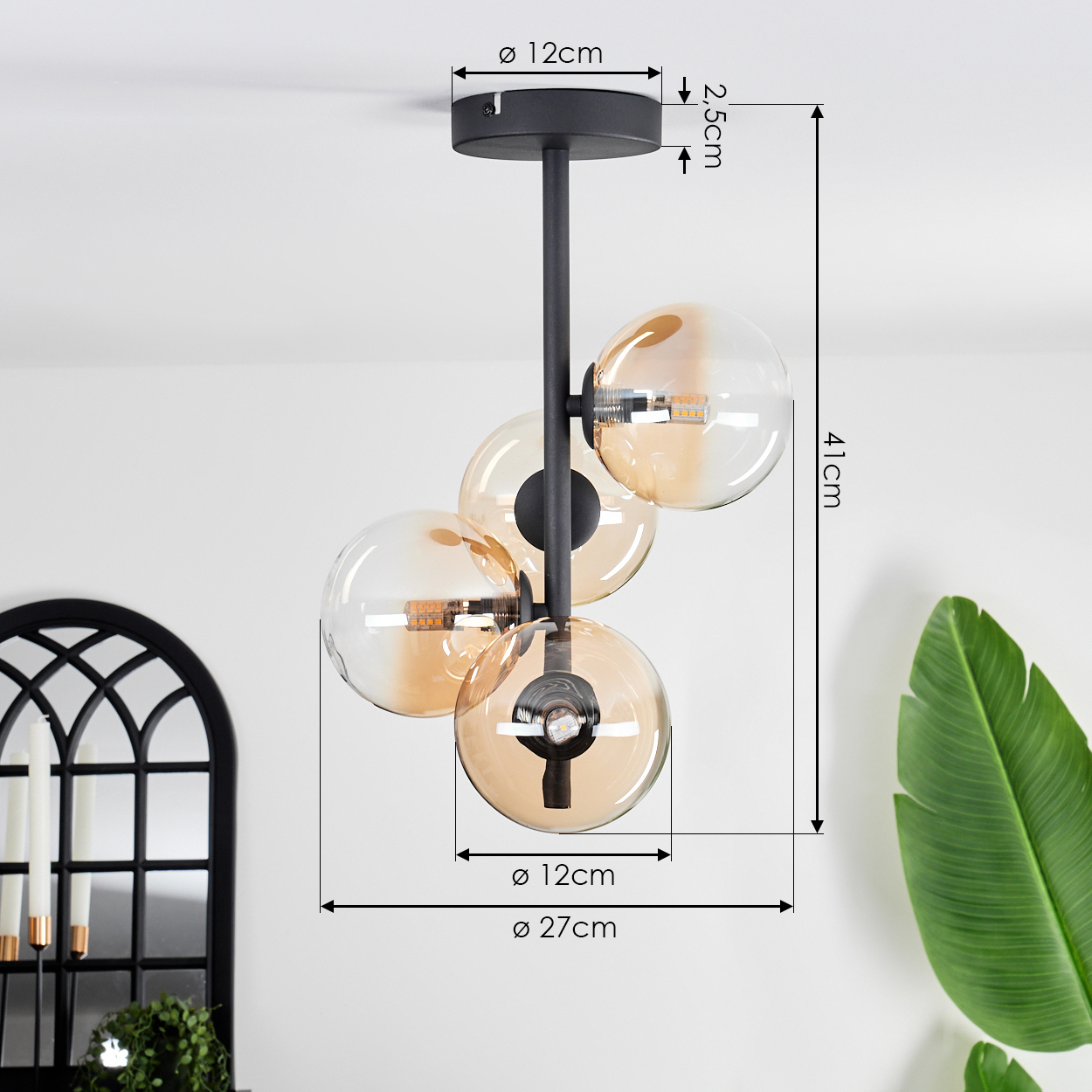 Nahaufnahme einer Deckenlampe mit vier bernsteinfarbenen Glaskugelschirmen. Der Hintergrund ist eine weiße Decke.