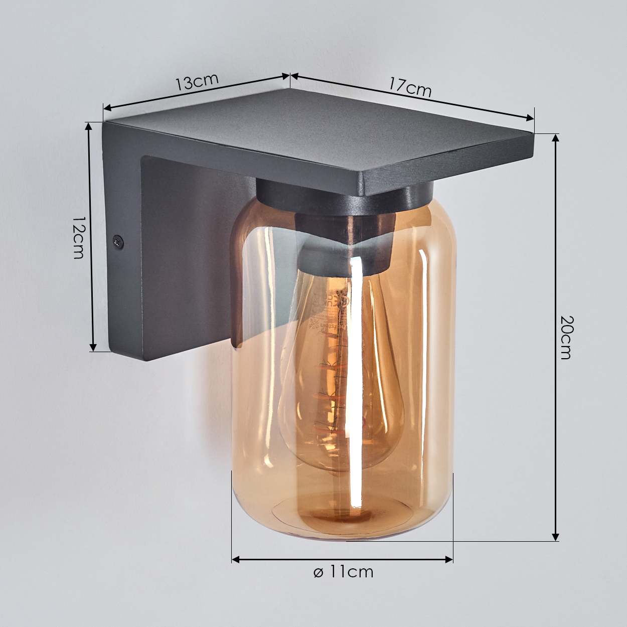 Schwarze Wandleuchte mit bernsteinfarbenem Glas, Abmessungen. Die Lampe ist an einer Wand montiert.