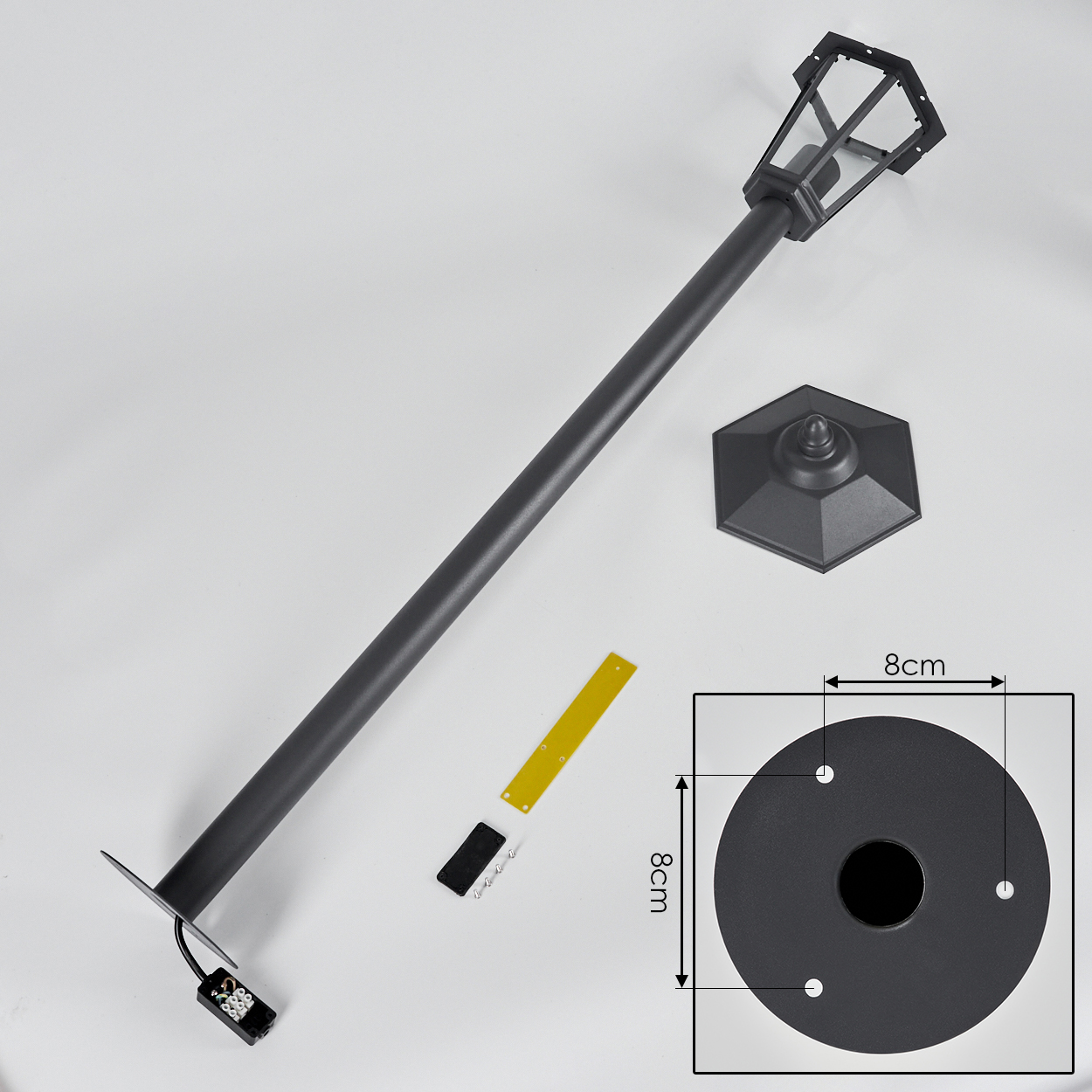 Eine zerlegte Außenlampe. Die Lampe ist schwarz und hat ein Maßetikett.