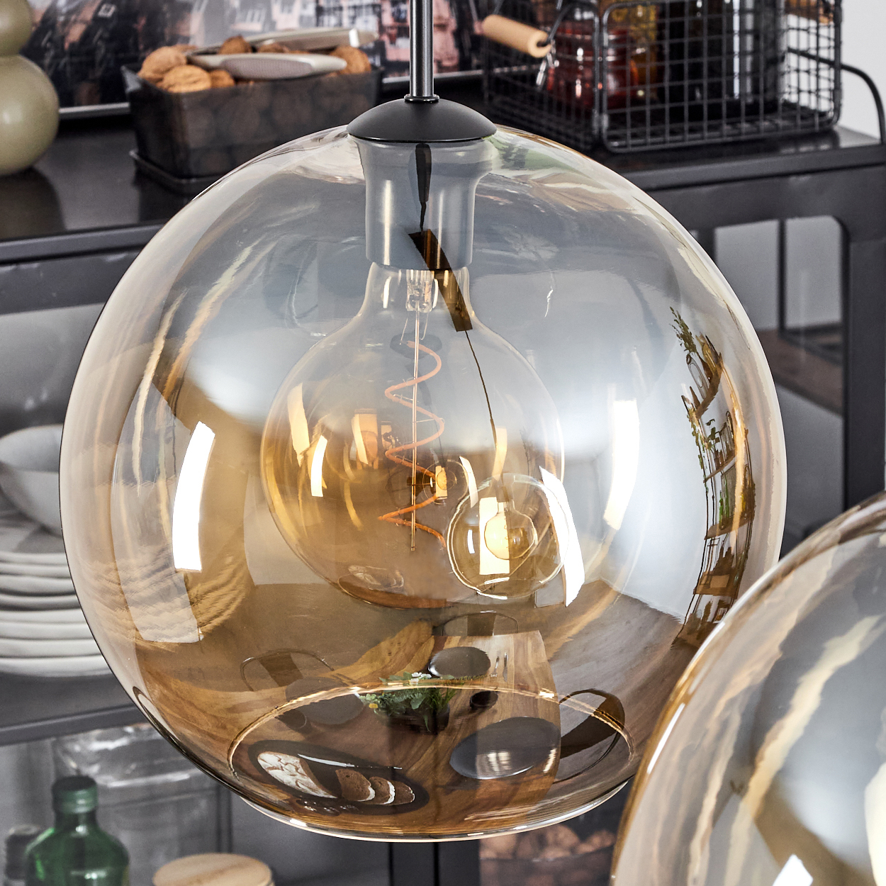 Nahaufnahme eines Glasschirms mit Glühbirne, mit bernsteinfarbenem Licht.