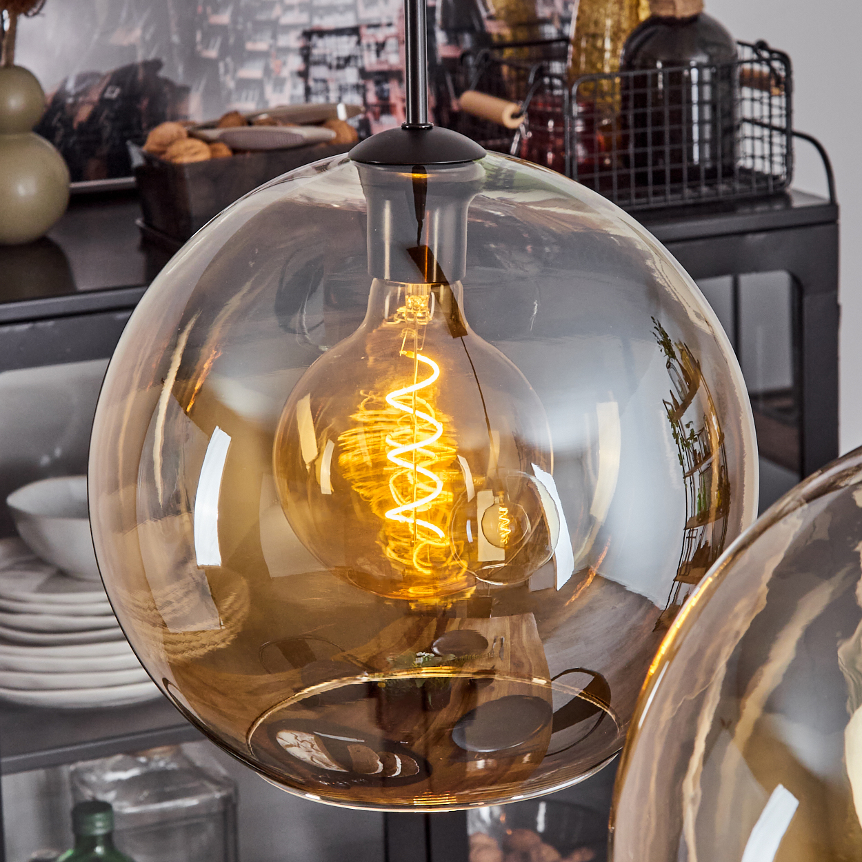 Nahaufnahme eines Glasschirms mit Glühbirne, mit bernsteinfarbenem Licht.