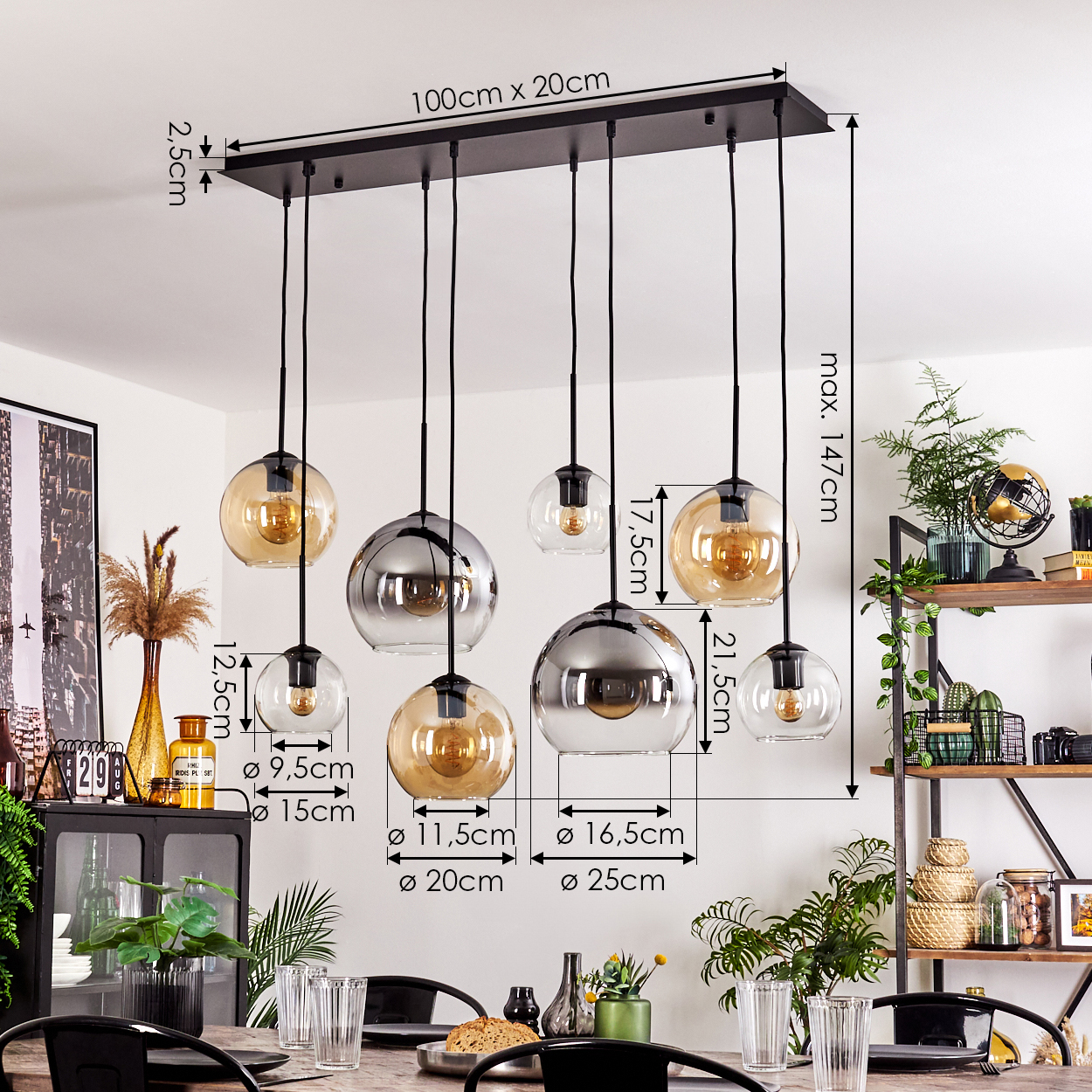 Esszimmer mit acht Pendelleuchten, bernsteinfarbenen und silbernen Glaskugeln, über einem Holztisch.