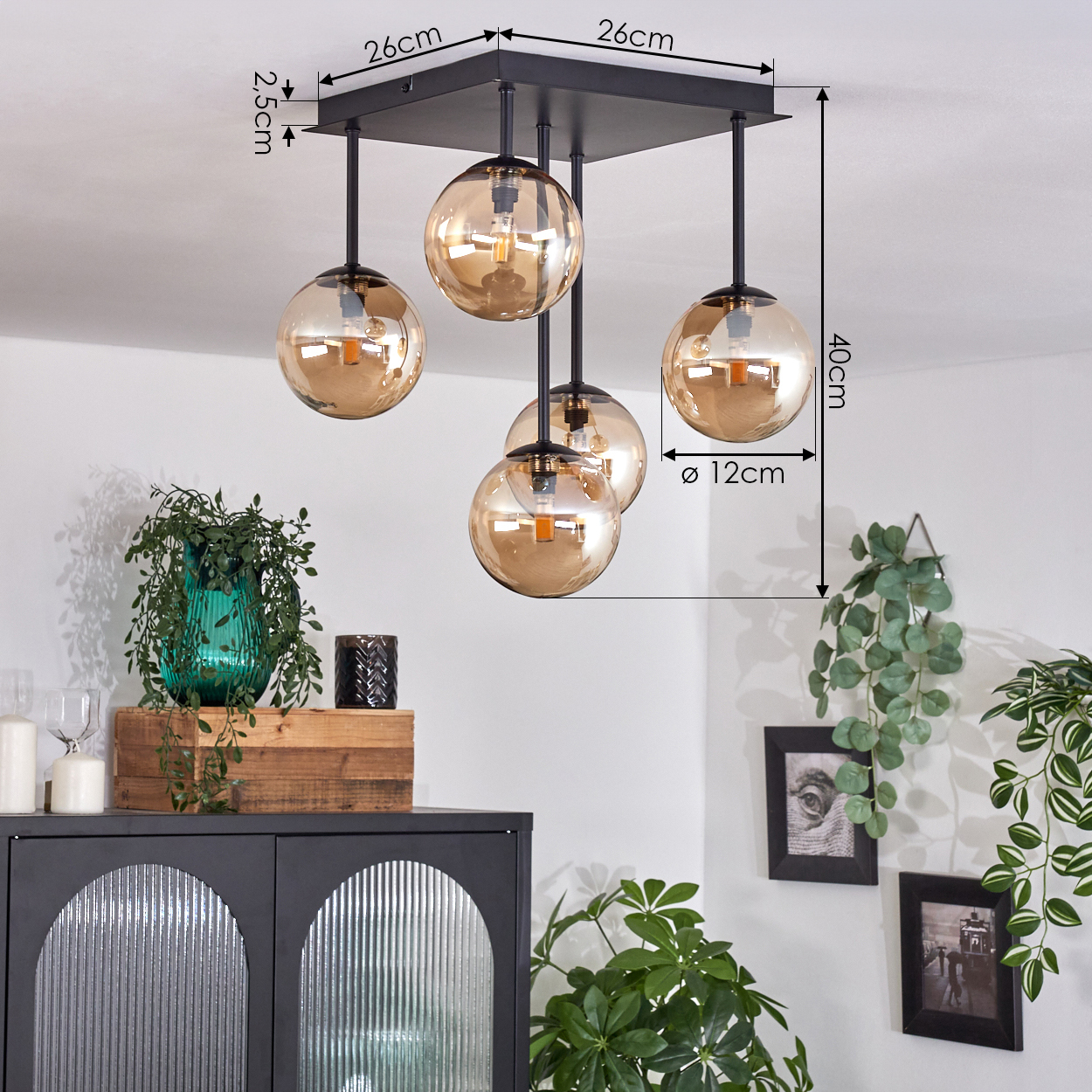 Deckenlampe mit fünf bernsteinfarbenen Glaskugel-Schirmen, schwarzen Halterungen, quadratischem Sockel.