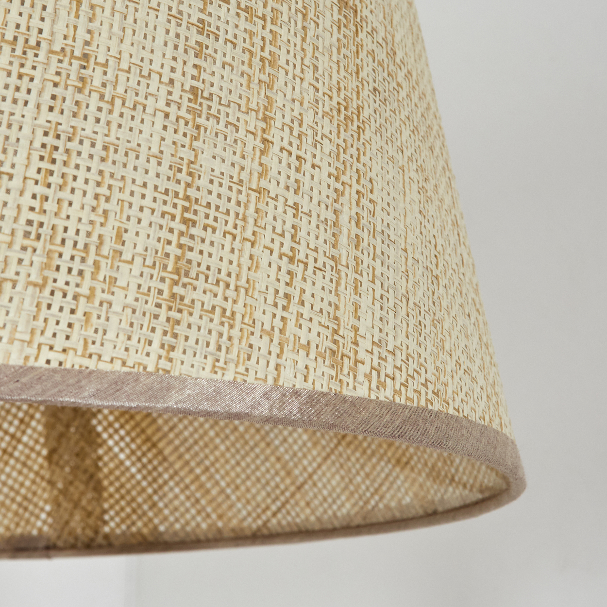 Nahaufnahme eines gewebten Lampenschirms mit beige-braunem Farbschema.