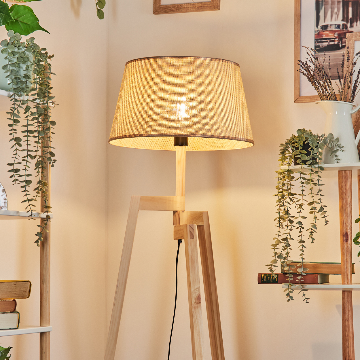 Holz-Stativ-Stehleuchte mit beigem gewebten Lampenschirm in einer Raumsituation.