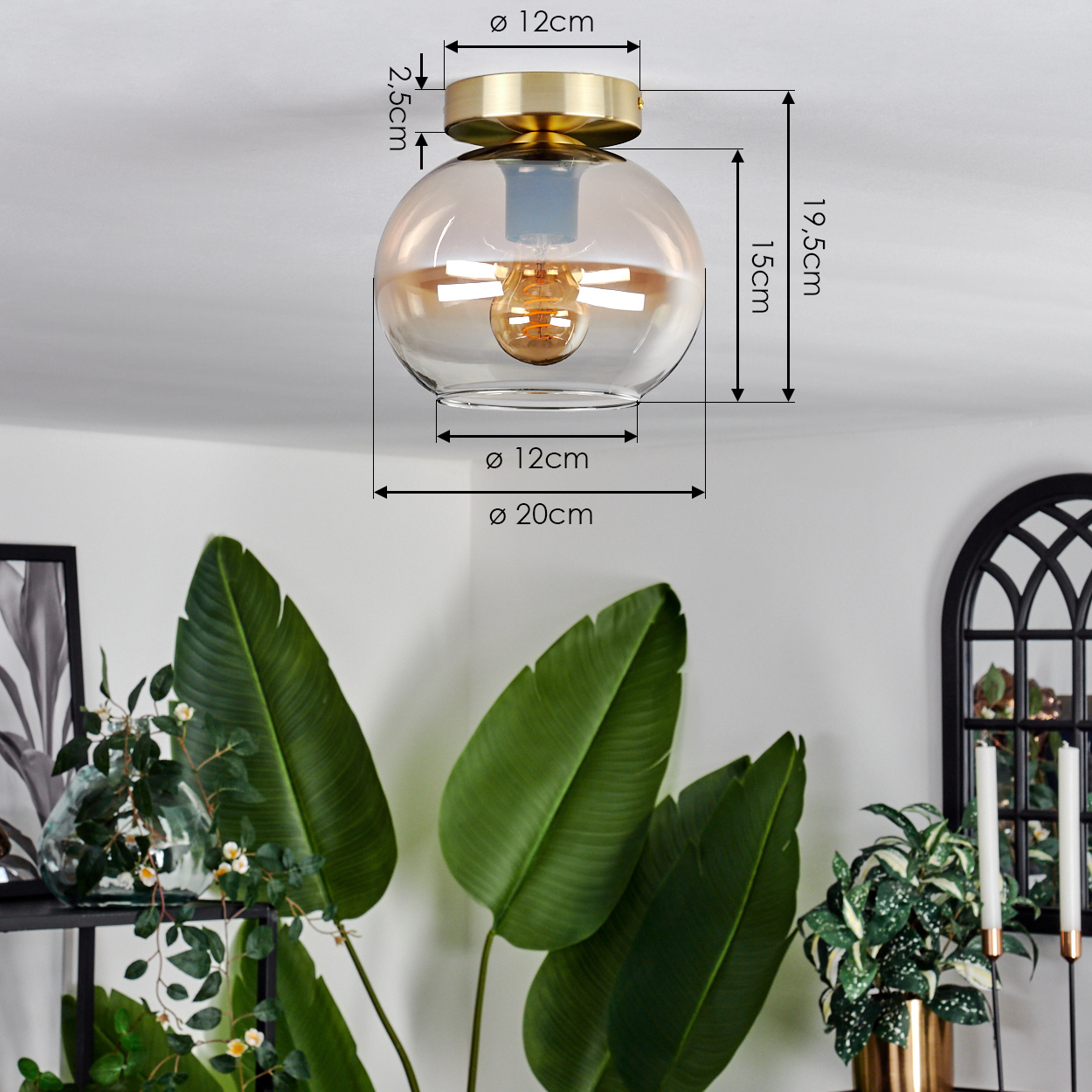 Nahaufnahme einer Deckenlampe aus Messing mit bernsteinfarbenem Glaskugel, Abmessungen und einer Pflanze im Vordergrund.