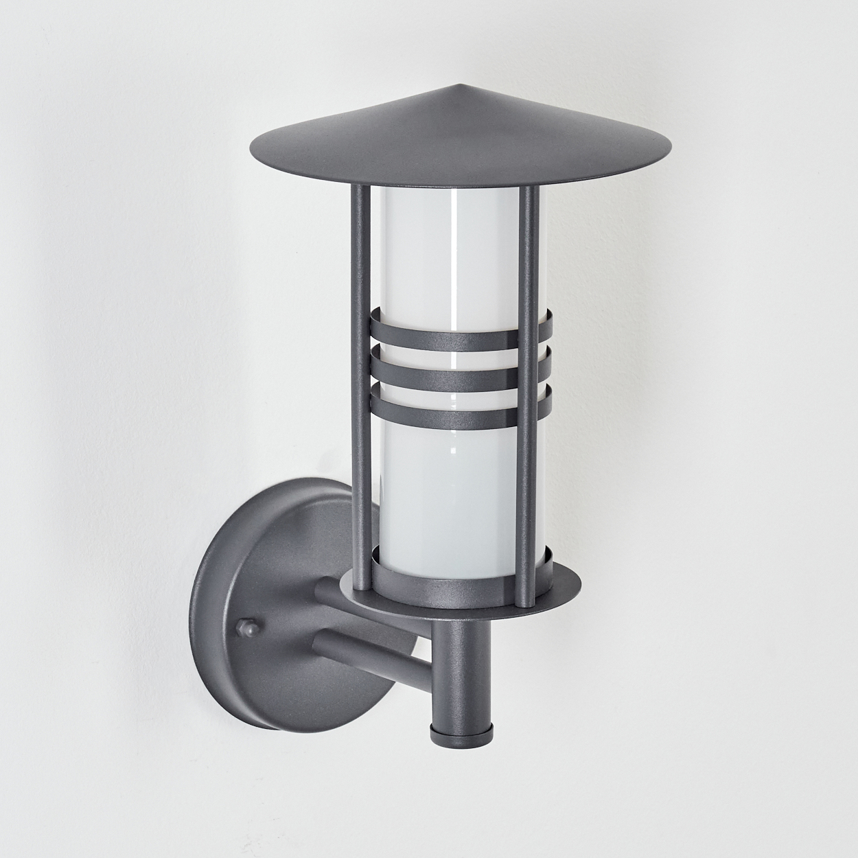 Außenwandleuchte ohne Licht. Zylindrischer Lichtdiffusor, konischer Schirm. Auf weißem Hintergrund montiert.