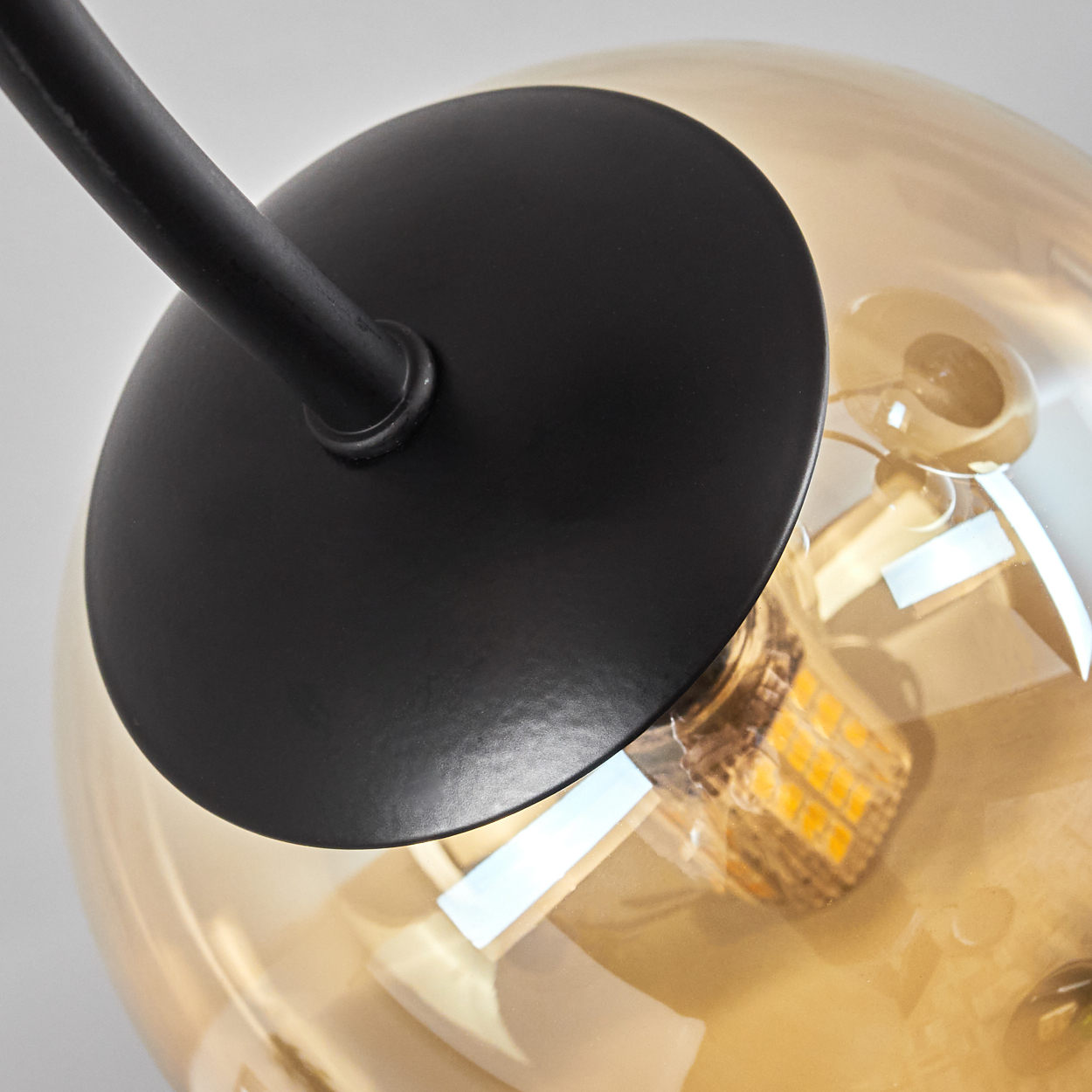 Nahaufnahme einer Lampe mit schwarzem Stiel und Glasschirm.