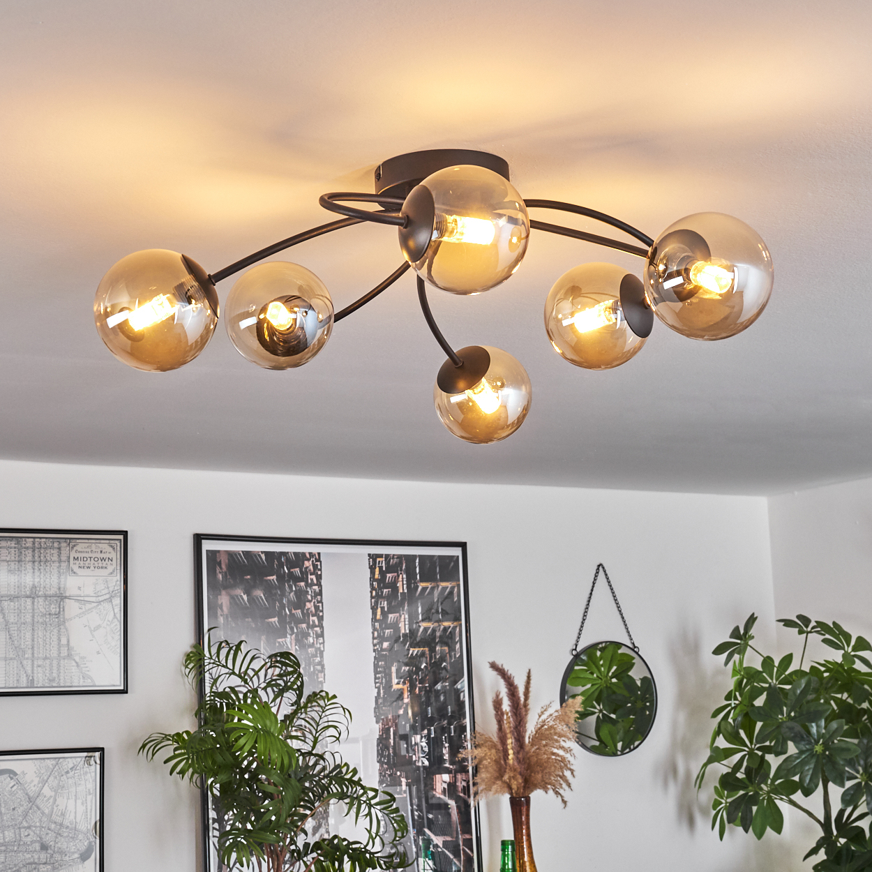 Eine Deckenlampe mit sechs Glasschirmen, jede mit einer Glühbirne, befindet sich in einem Raum.