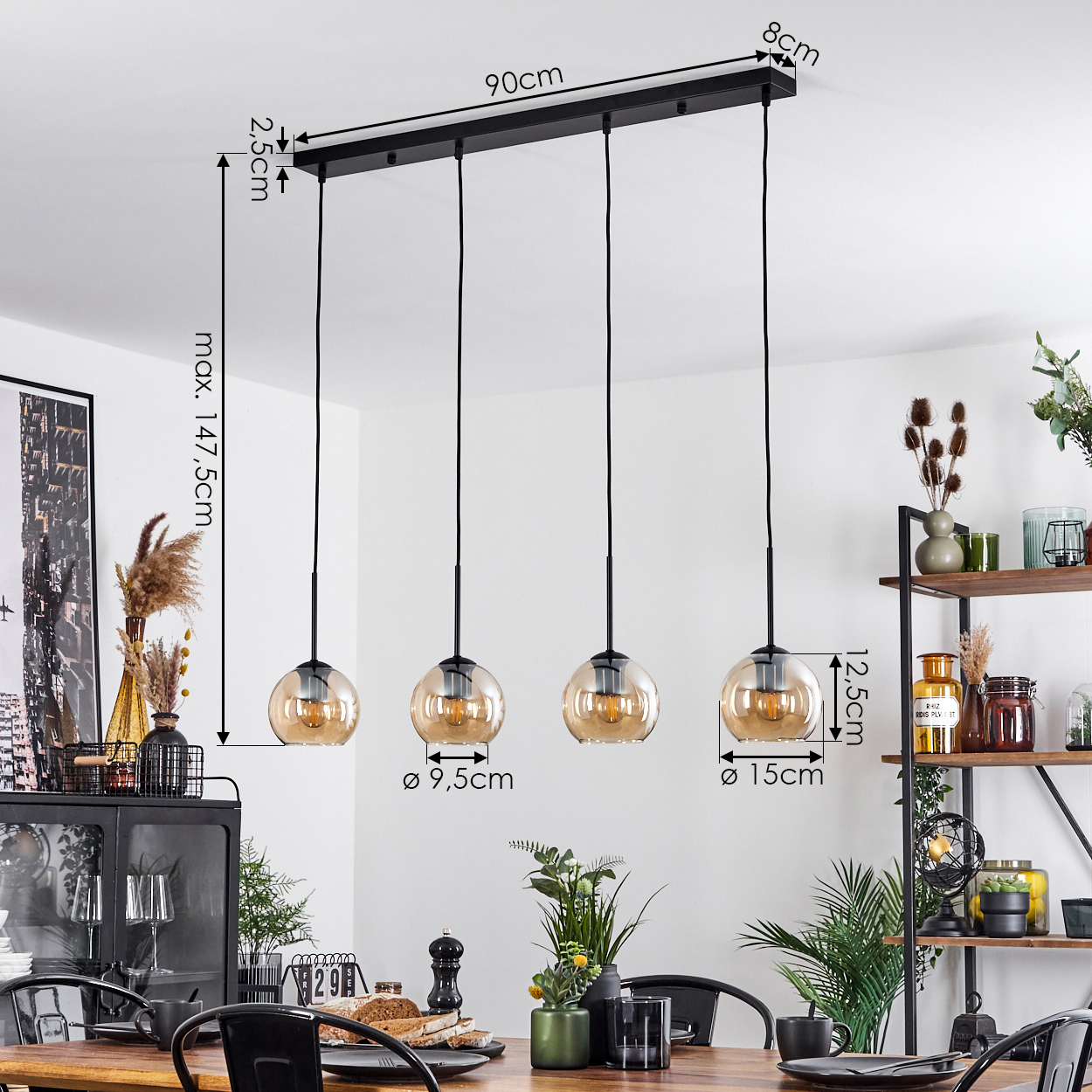 Esszimmer mit vier bernsteinfarbenen Pendelleuchten, schwarzem Tisch und angezeigten Abmessungen.