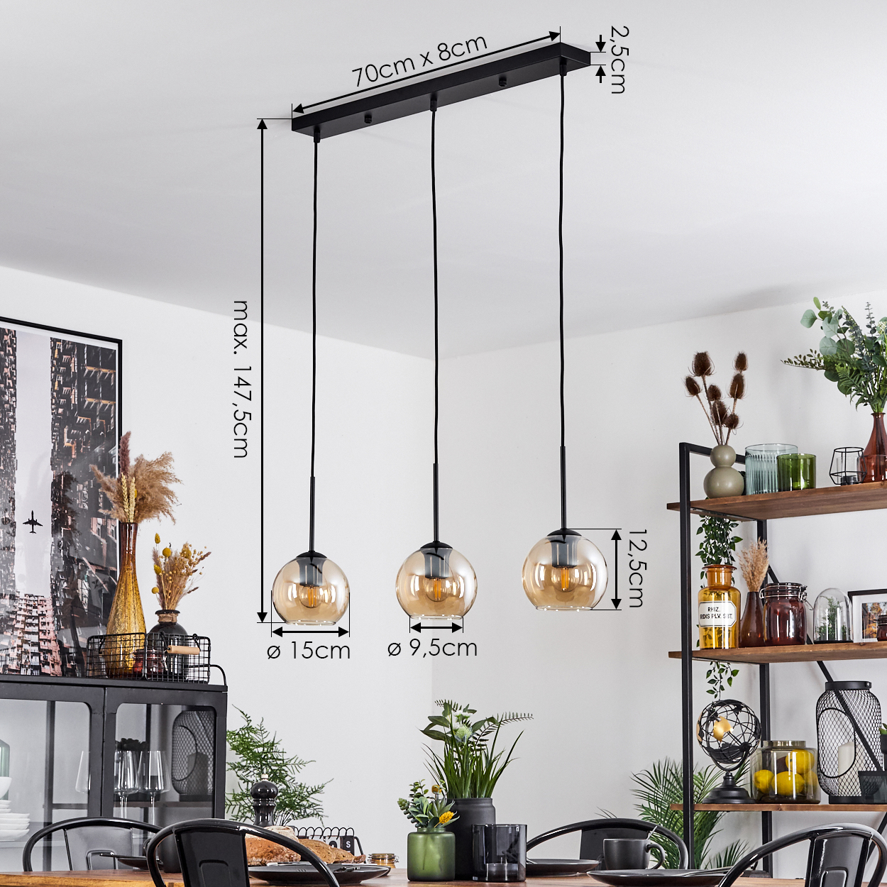 Ein Esszimmer mit drei Pendelleuchten. Die Leuchten haben bernsteinfarbene Glasschirme. Abmessungen sind ebenfalls enthalten.