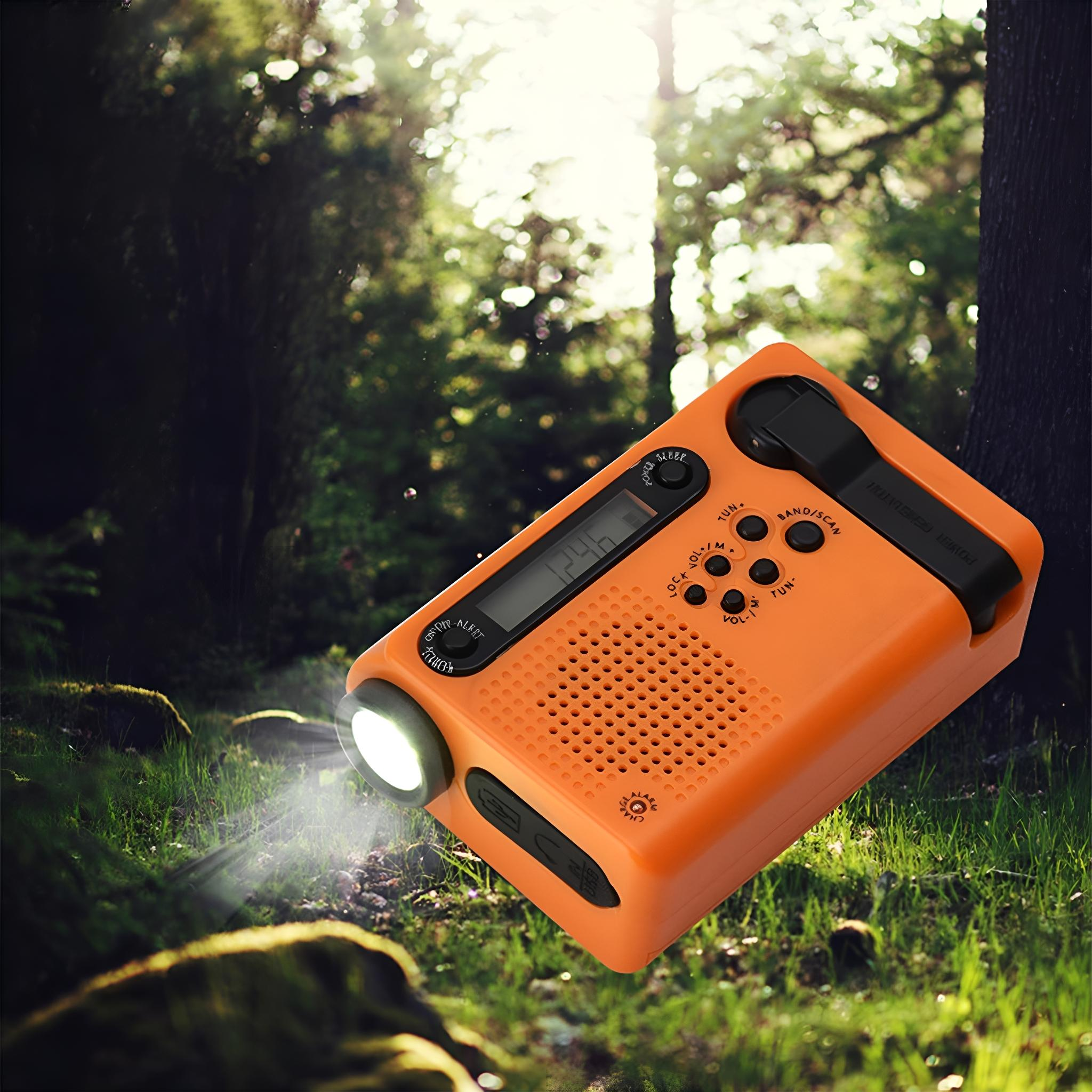 Oranges Notfallradio mit Kurbel und Taschenlampe im Wald.