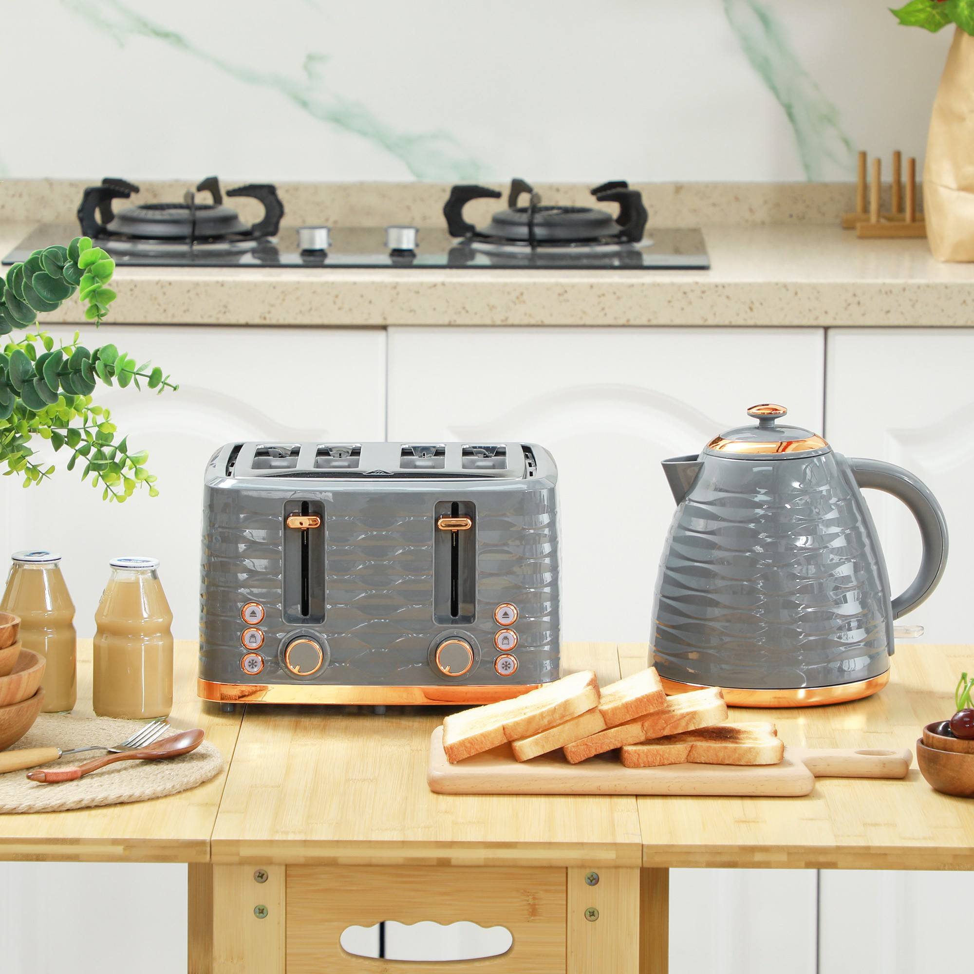 Grauer und goldener Toaster, Wasserkocher und Lebensmittel auf einem Holztisch. Küchenhintergrund.