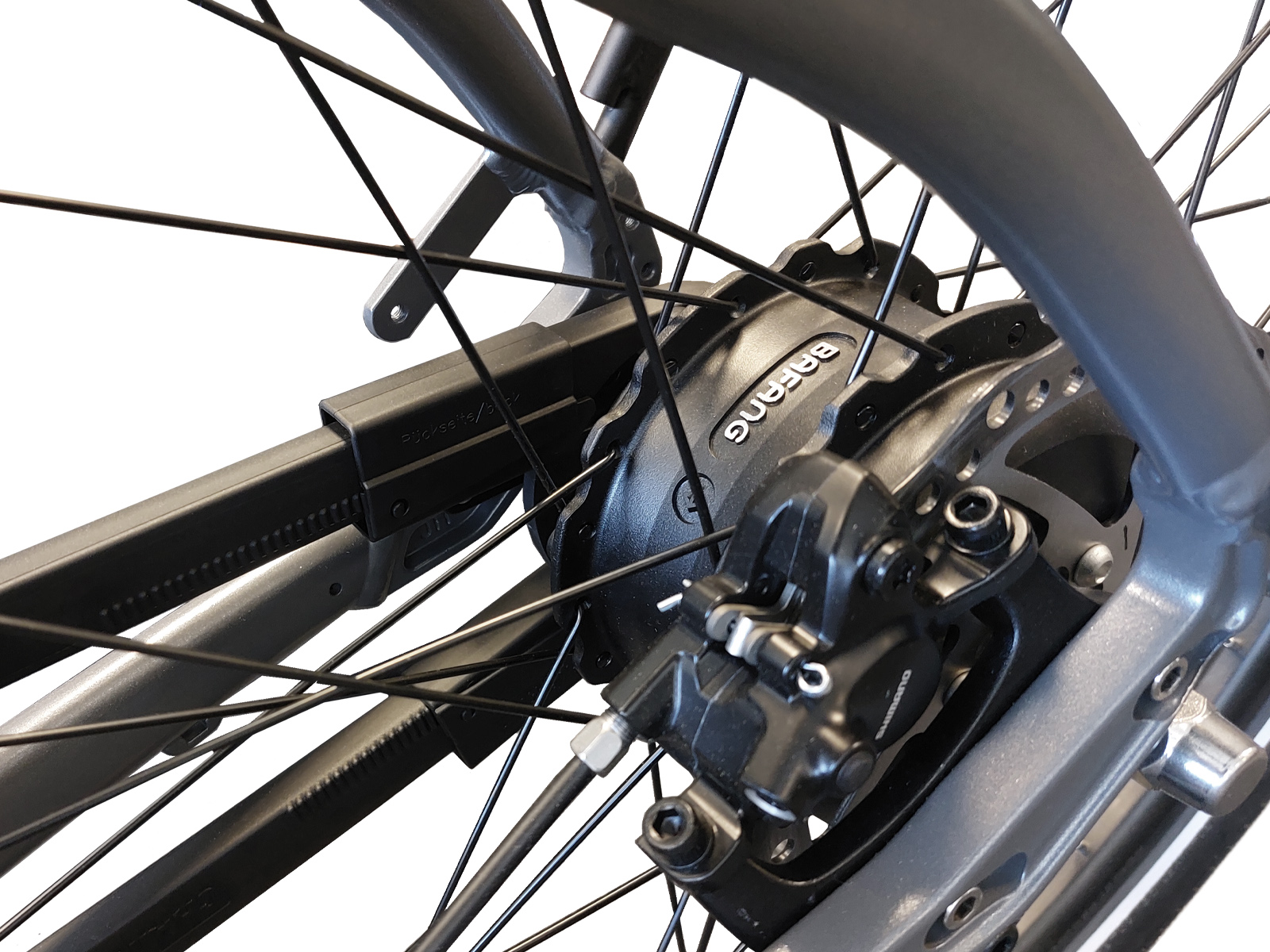 Nahaufnahme der Hinterradkomponenten eines Fahrrads, einschließlich eines Bafang-Motors und einer Bremse.