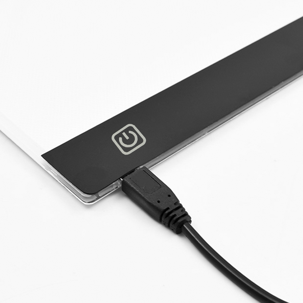 Primer plano de un panel de luz con un botón de encendido y un cable USB enchufado.