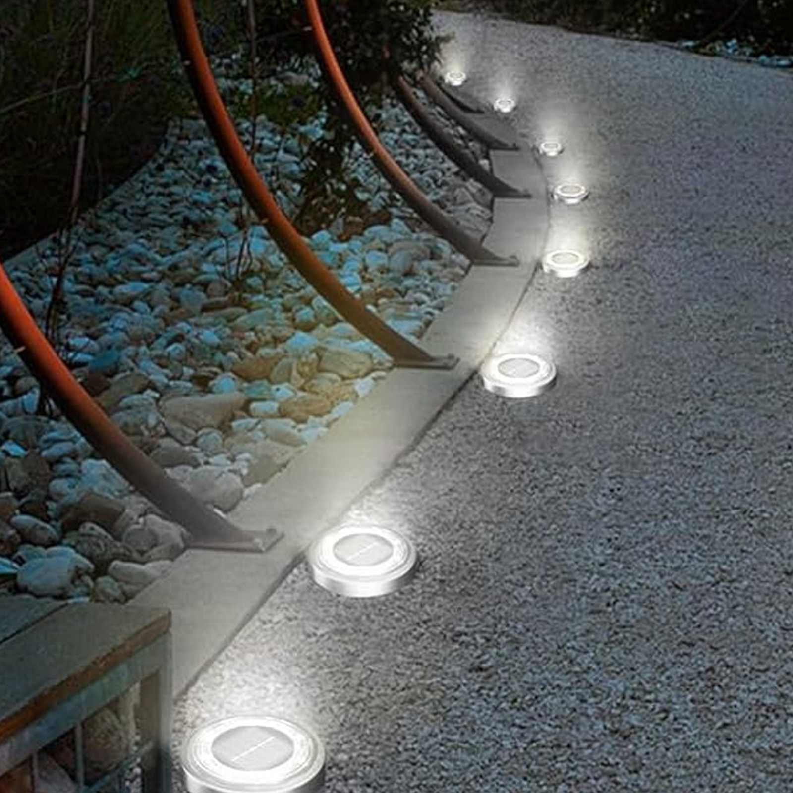 Mehrere Solarlampen sind entlang eines Weges aus Steinen platziert.