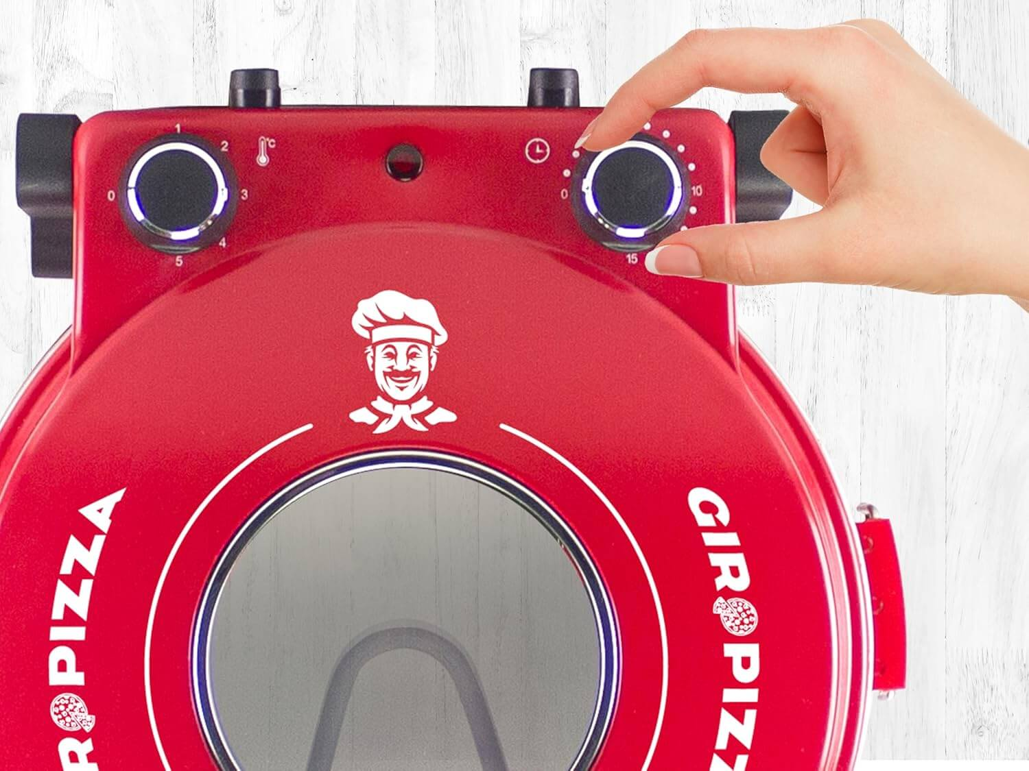 Una mano che imposta il timer su un forno Giro Pizza rosso, che ha anche un logo dello chef sorridente.