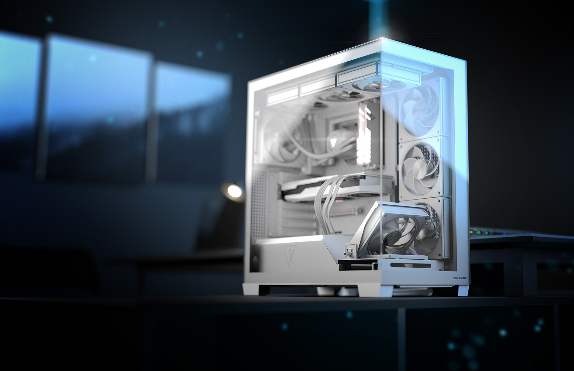 Biała obudowa komputera na biurku z rozmytym tłem ciemnego pokoju. Widoczna lampa i monitory.