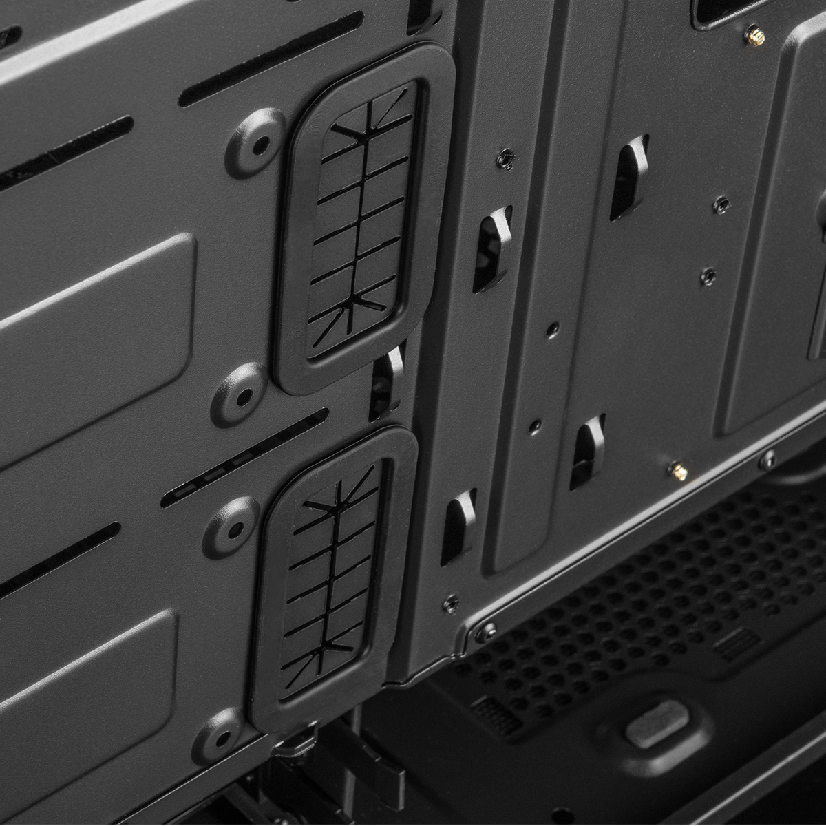 Zbliżenie wnętrza obudowy komputera pokazujące otwory do zarządzania kablami.