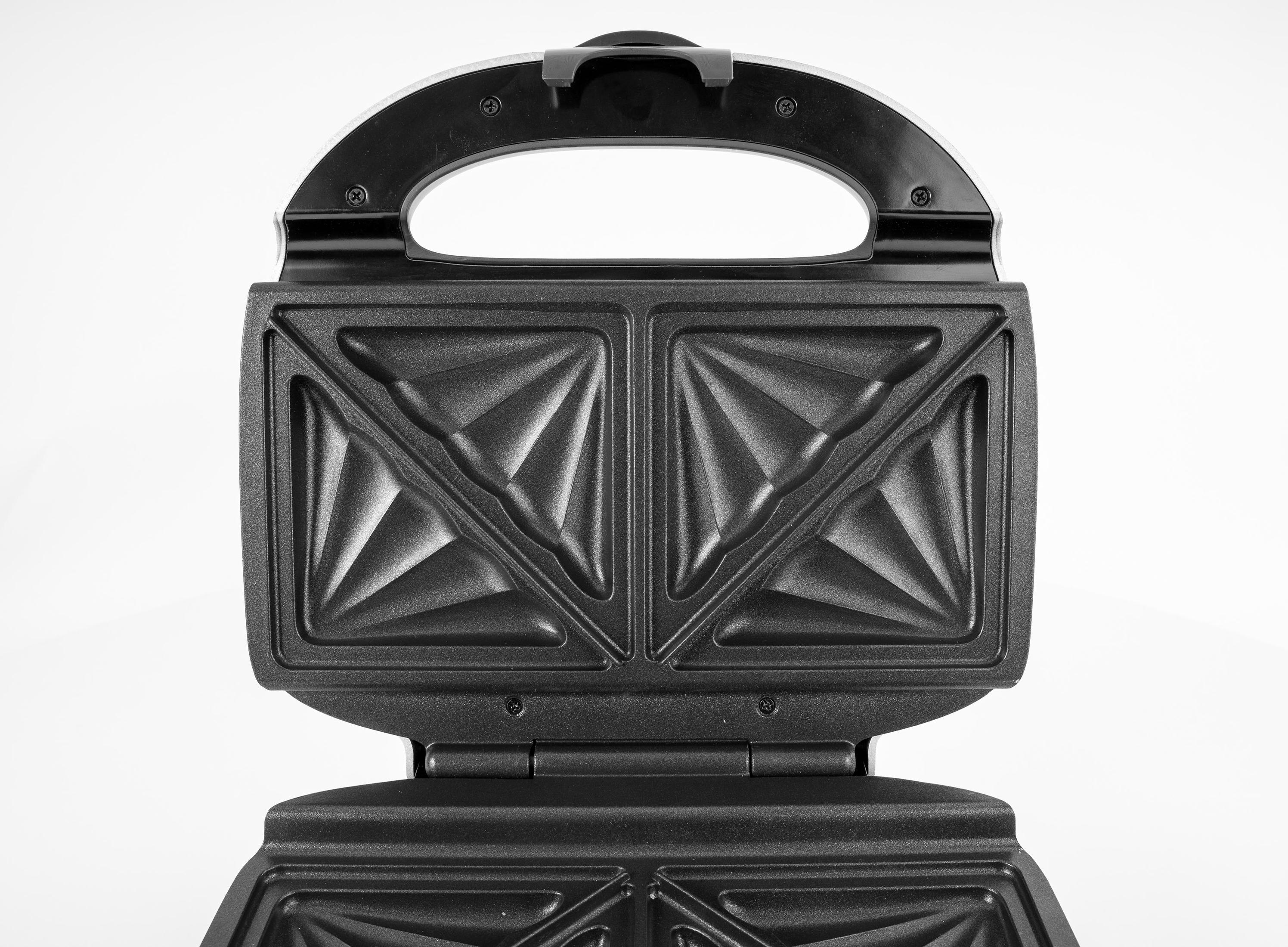 Otwarty czarny opiekacz do kanapek, widok z góry. Wnętrze ma wzorzystą teksturę. Uchwyt u góry, białe tło.