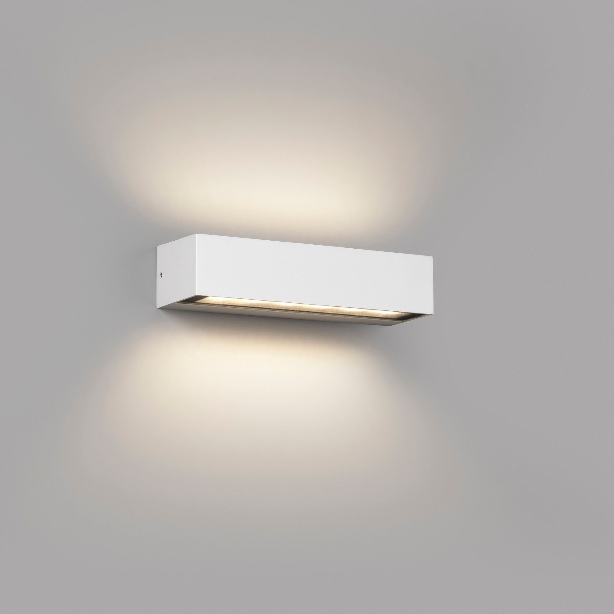 Luce da parete rettangolare bianca montata su un muro grigio, che emette luce verso il basso.