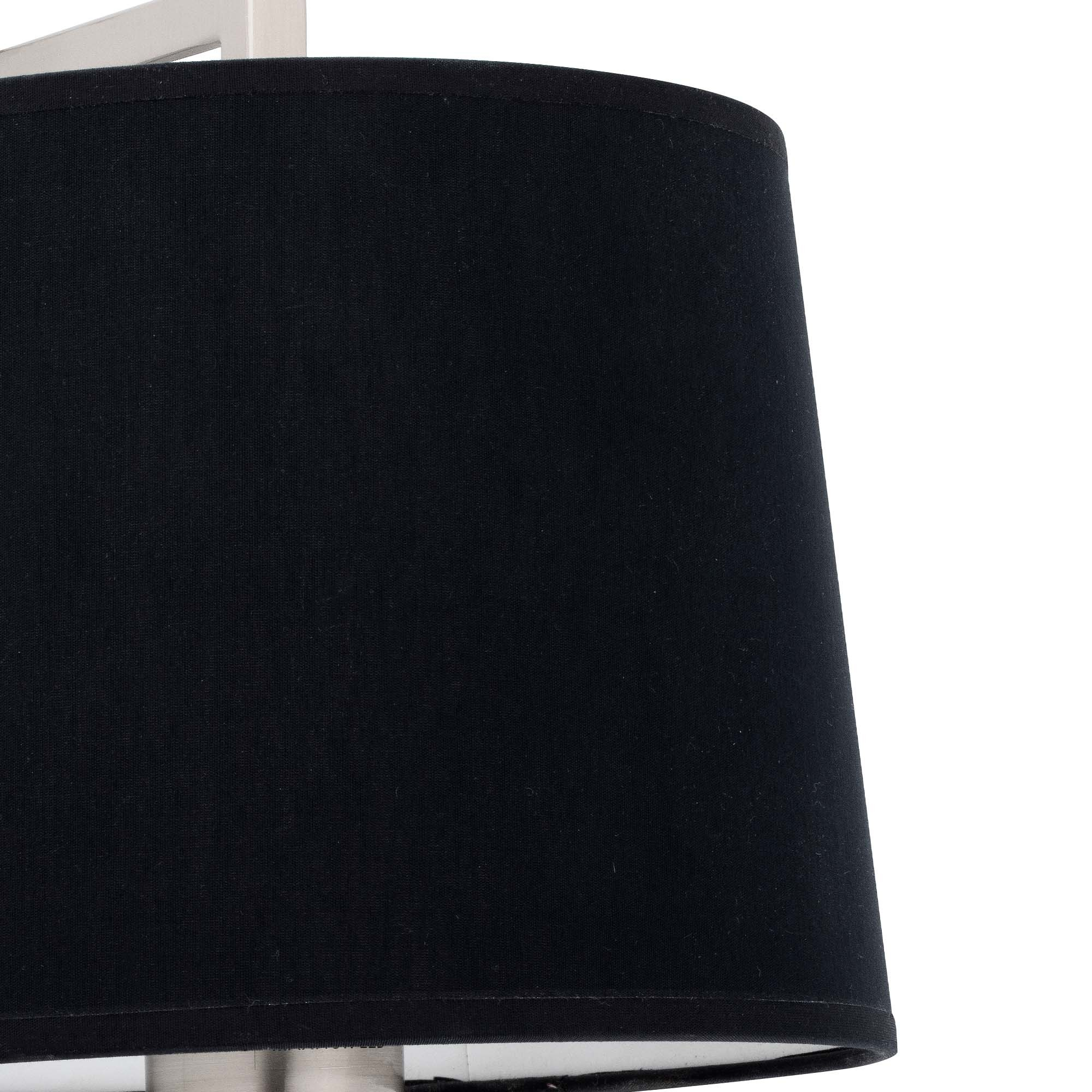Primo piano di un paralume nero con interno bianco e base argentata.