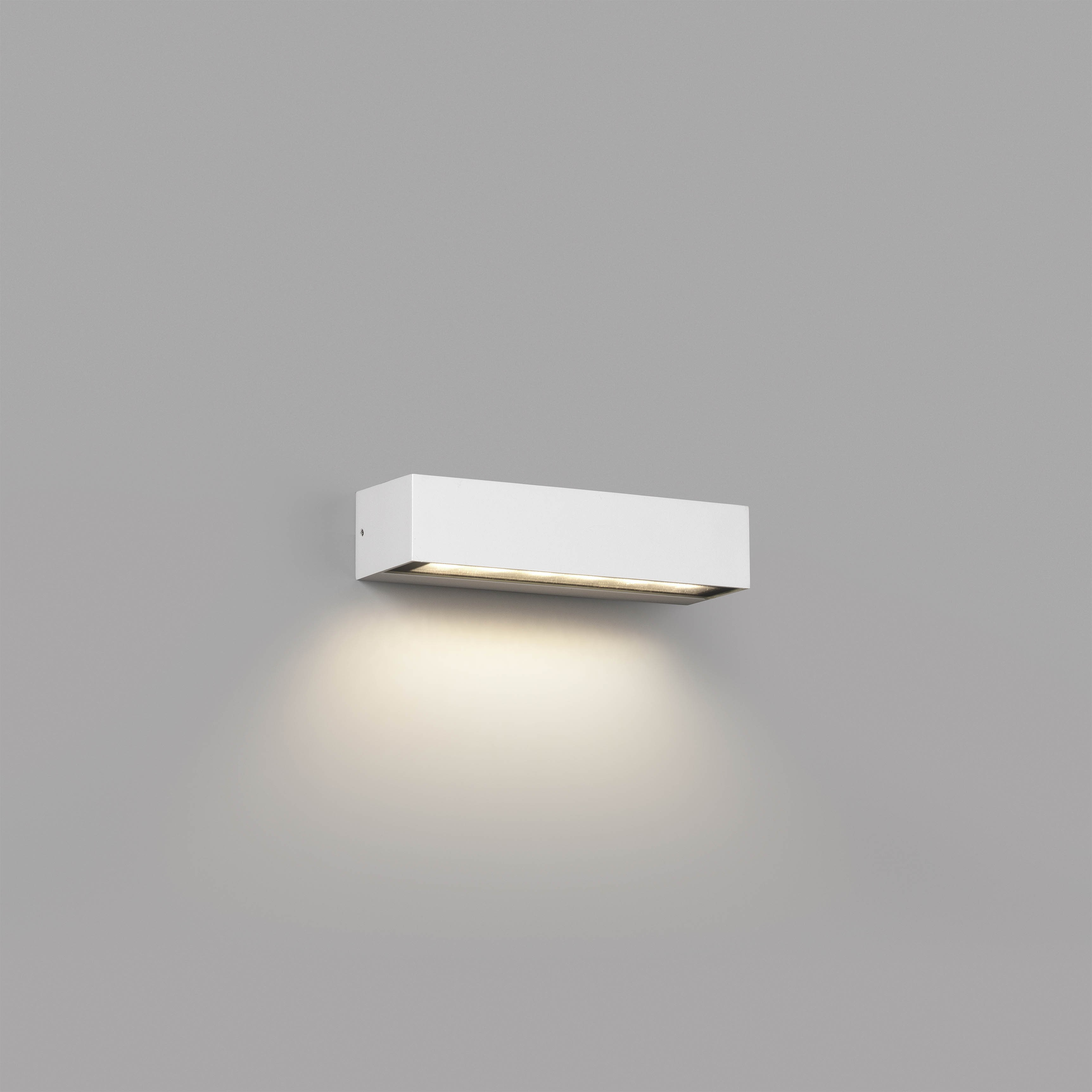 Una lampada da parete rettangolare bianca che proietta la luce verso il basso su un muro grigio.