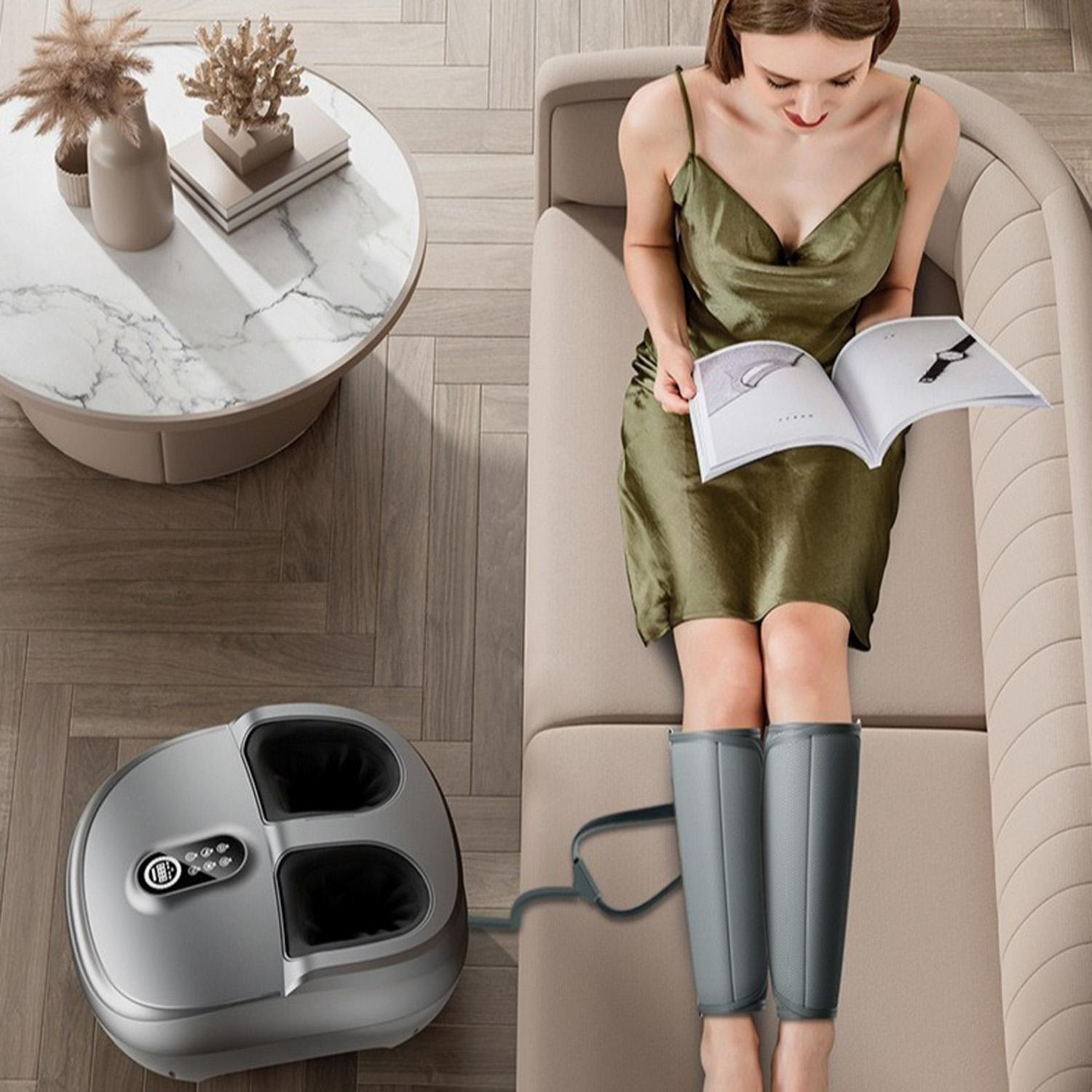 Frau benutzt ein Beinmassagegerät. Sofa und Tisch im Hintergrund.