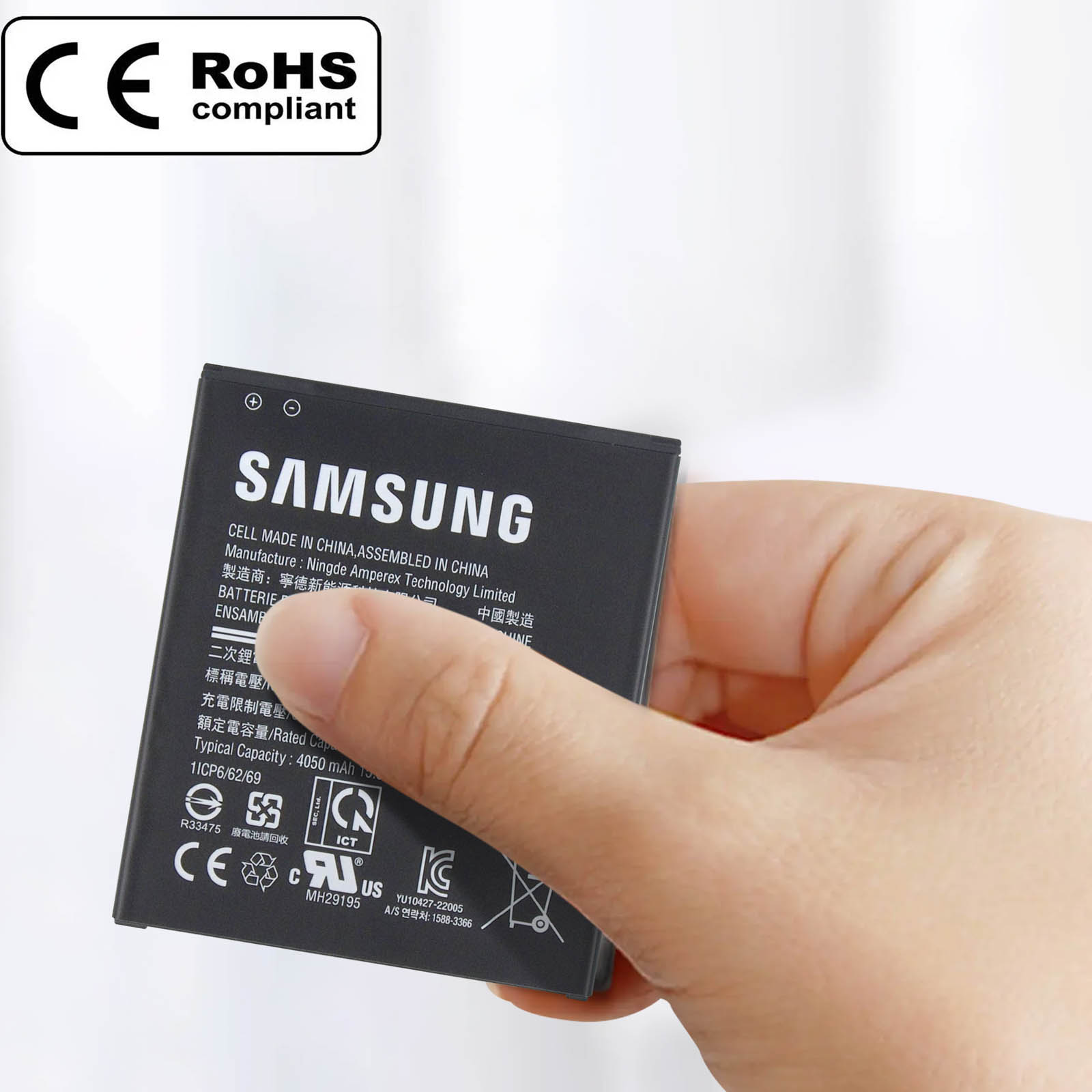 Batteria Samsung tenuta in mano. Batteria nera ed etichetta bianca.