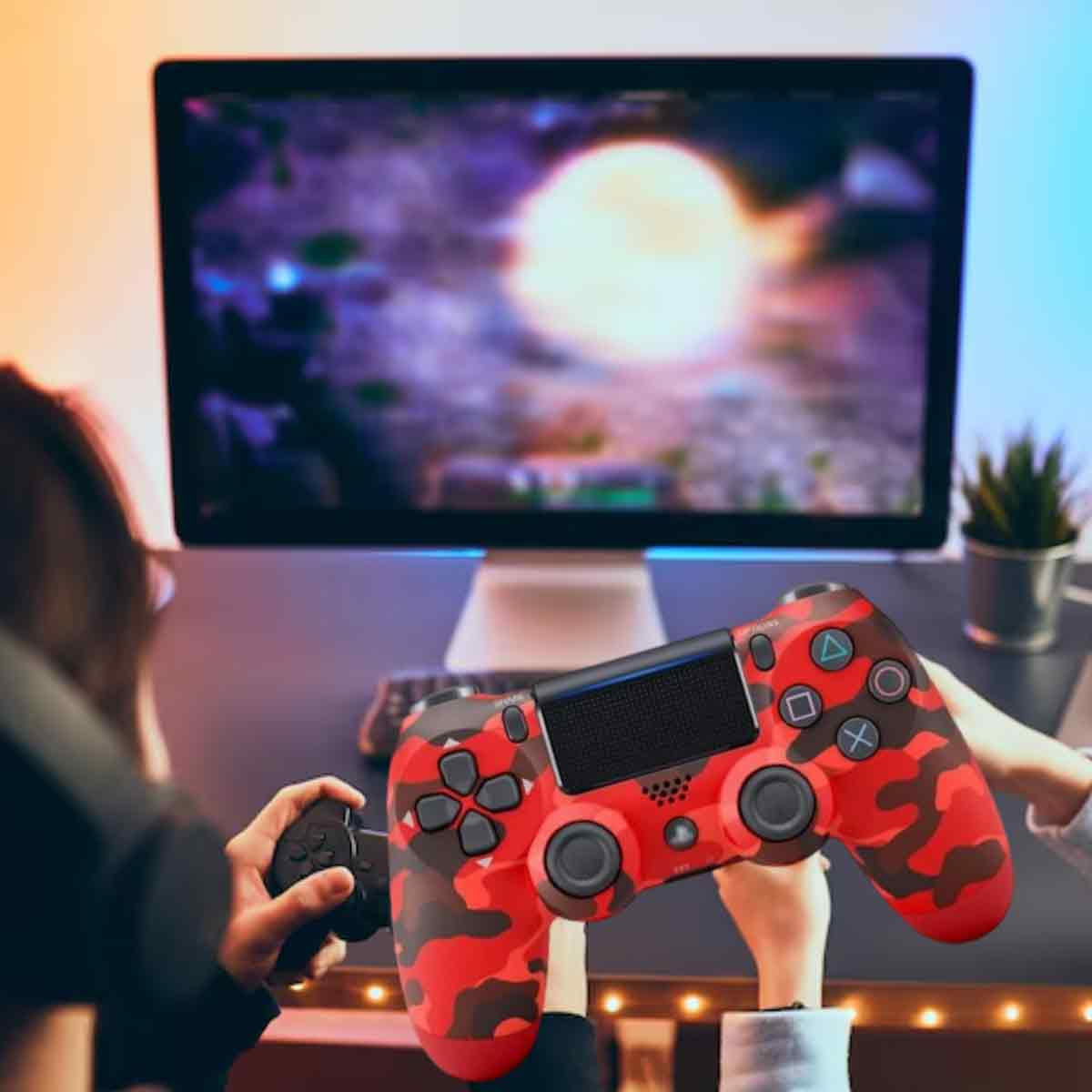 Eine Person, die einen roten Camouflage-Controller vor einem Computerbildschirm hält und ein Spiel spielt.