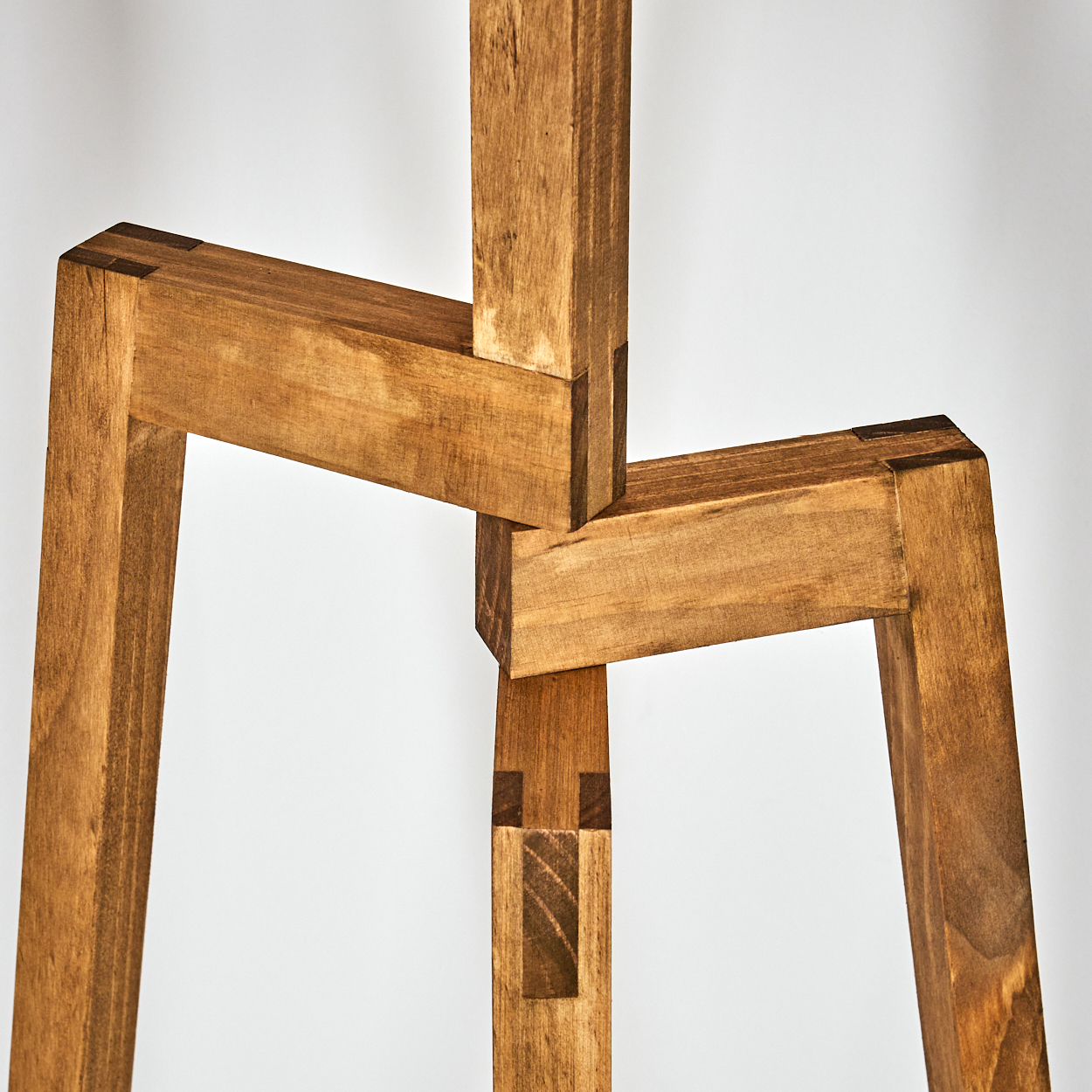 Nahaufnahme des Holzrahmens der Lampe. Verbindungen sichtbar. Weißer Hintergrund.