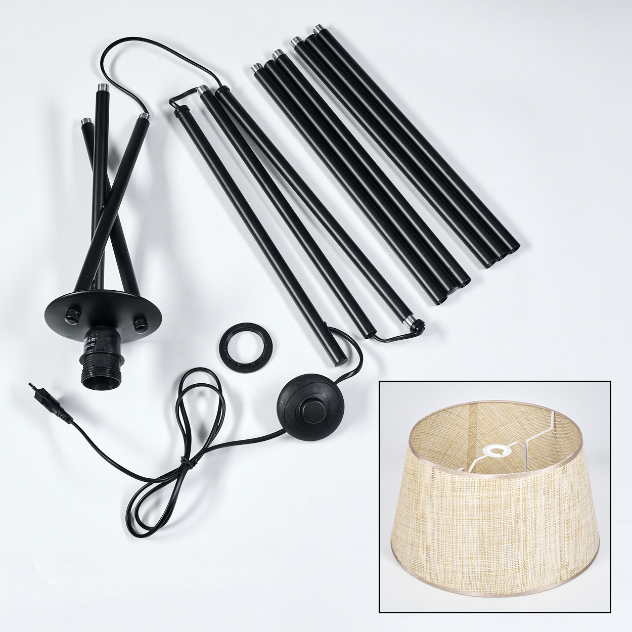 Komponenten einer Stehlampe: Beine, Schirm, Elektrokabel und Schalter auf weißer Oberfläche.