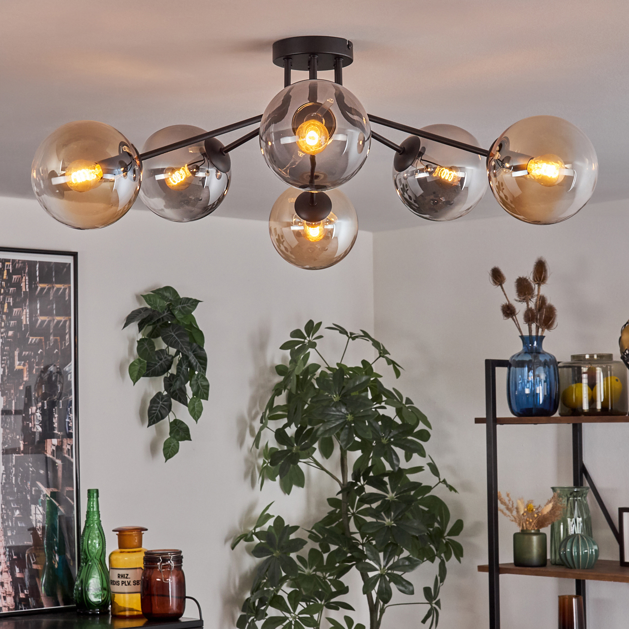 Deckenlampe mit sechs bernsteinfarbenen Glaskugeln, sichtbaren Glühbirnen und schwarzer Halterung.