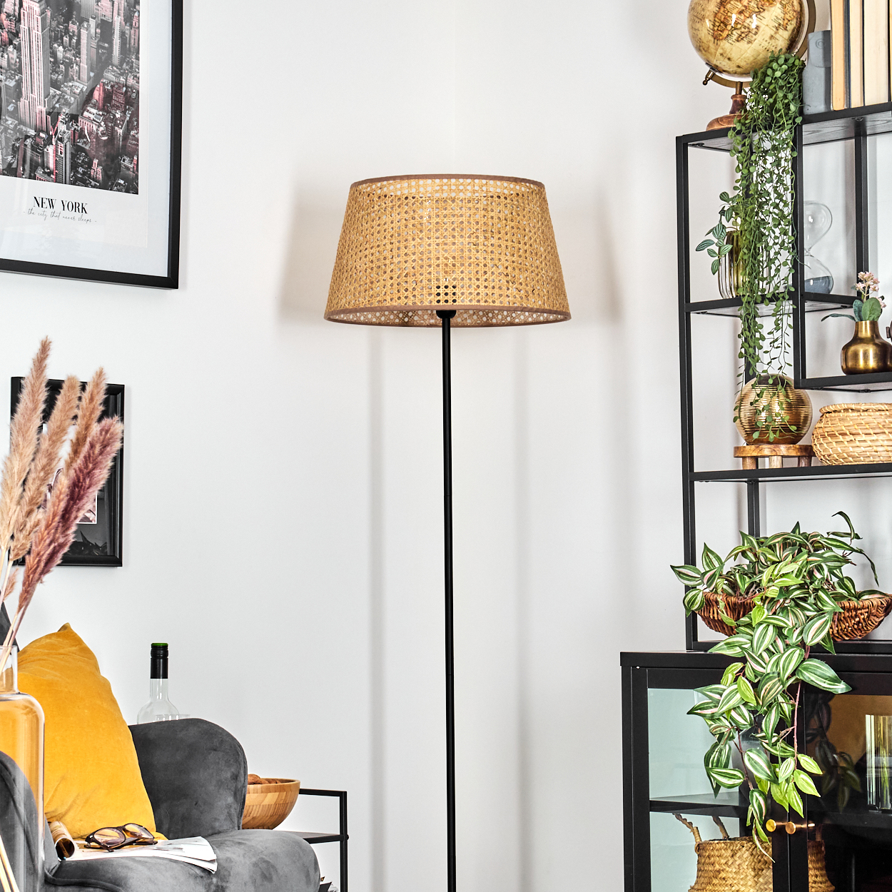 Eine Stehlampe mit Rattanschatten in einem dekorierten Raum.