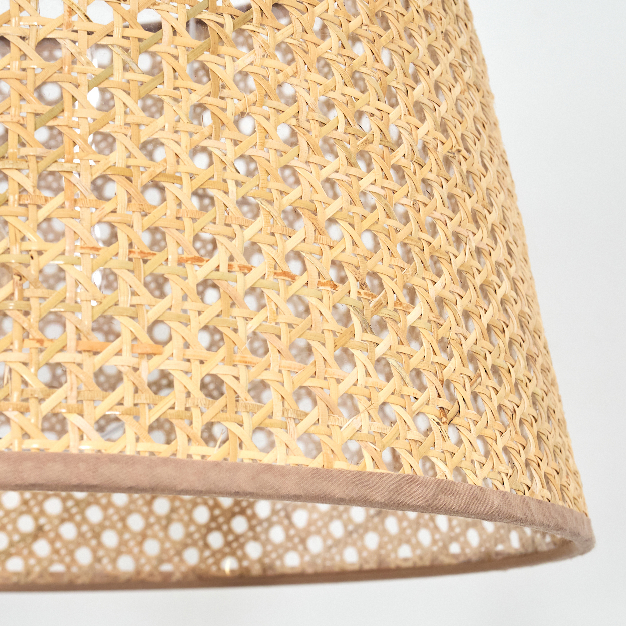 Gewebter Lampenschirm, Nahaufnahme. Natürliches Rattan, braune Verzierung, detailliertes Muster.  Weißer Hintergrund.