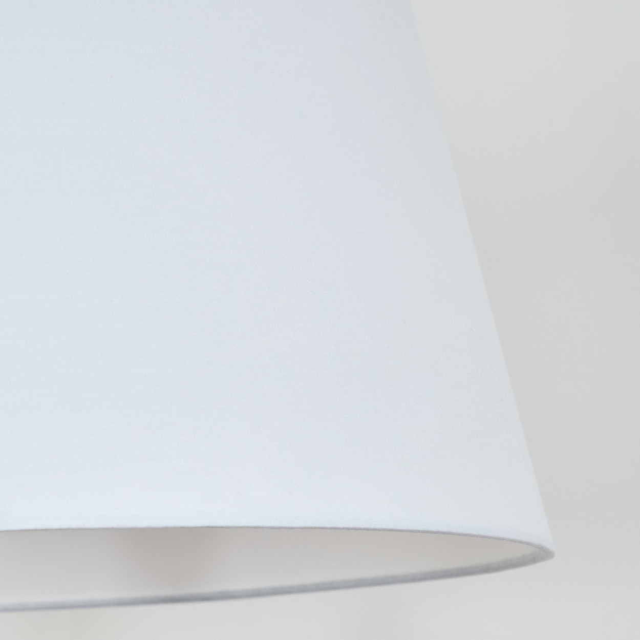Weißer Lampenschirm, Nahaufnahme. Glatte, geschwungene Form, von innen beleuchtet. Weiches Licht.
