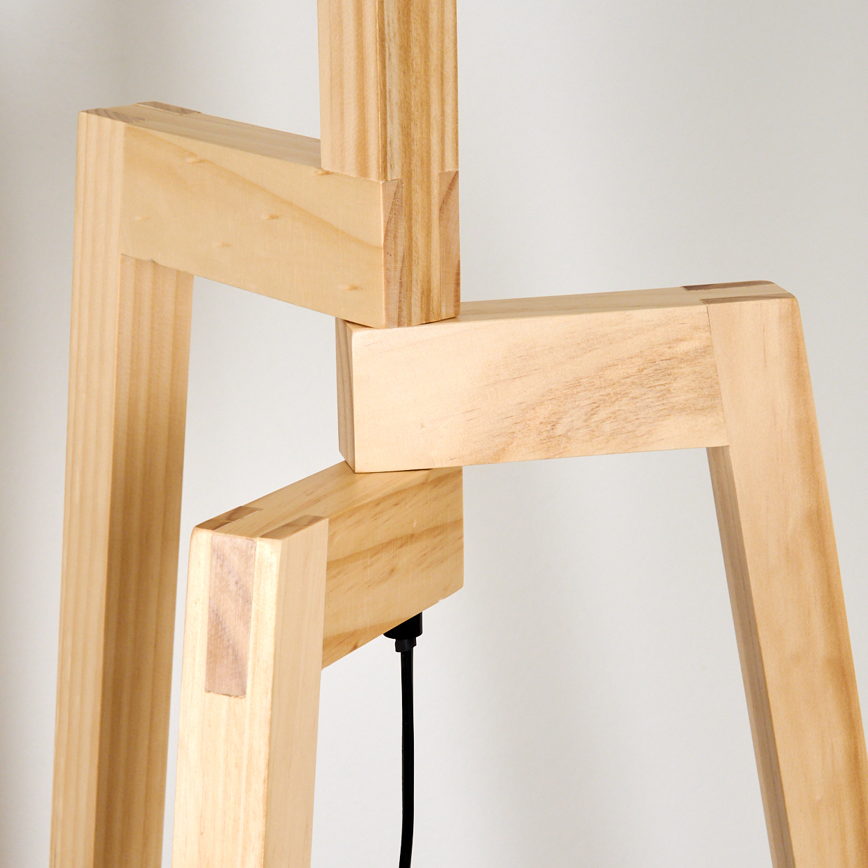 Nahaufnahme des Holzbeinanschlusses einer Stativ-Stehlampe.