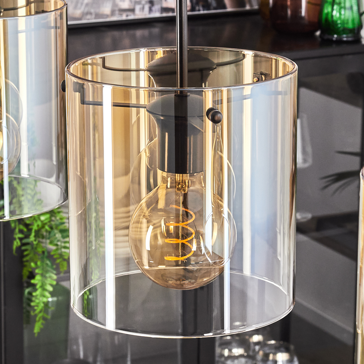 Drei hängende Lampen. Jede hat einen Glaszylinder. Die Glühbirnen sind sichtbar.