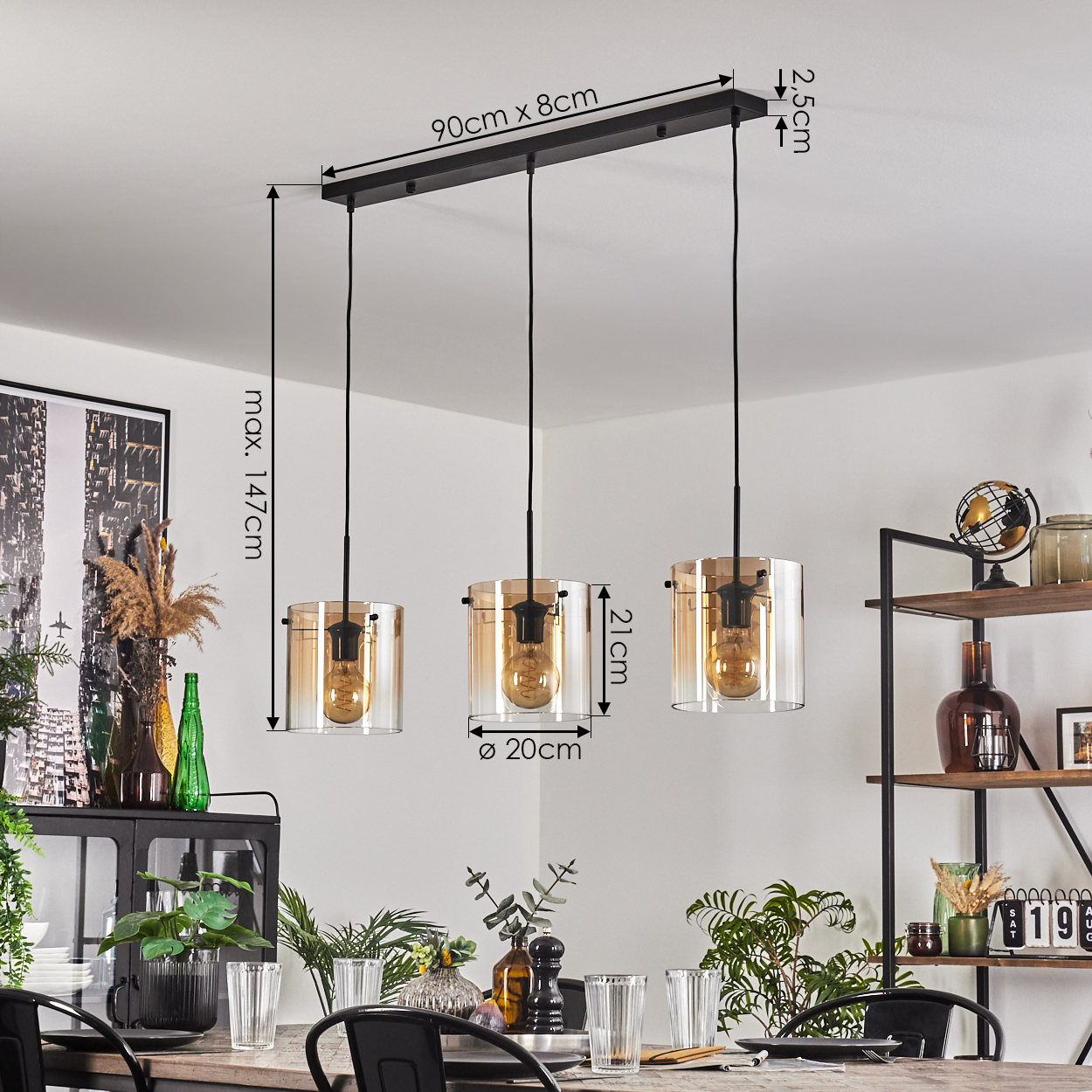 Drei Pendelleuchten mit bernsteinfarbenen Glasschirmen und Edison-Glühbirnen, hängend.