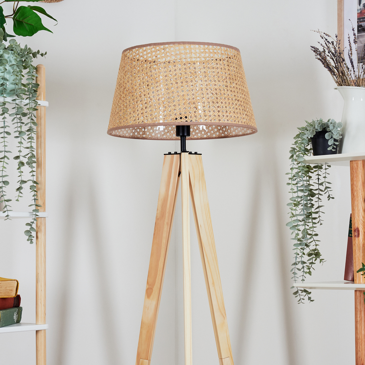 Holz-Stativlampe mit gewebtem Schirm in einem dekorierten Raum.