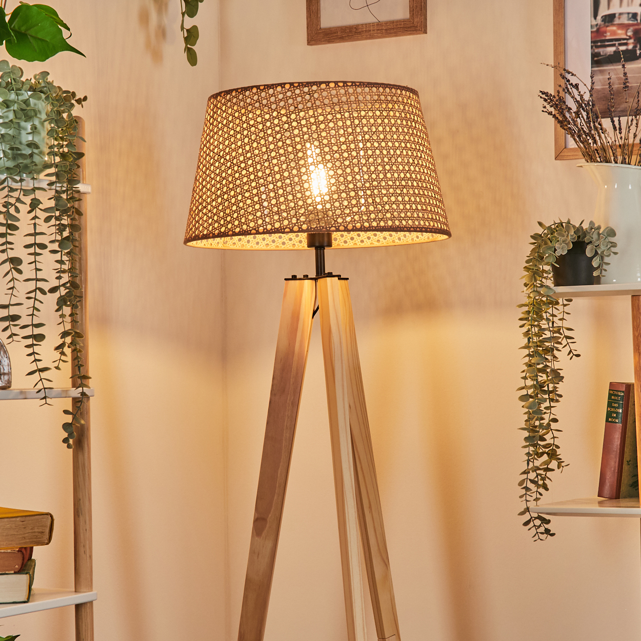Innenaufnahme einer Holz-Stativlampe mit gewebtem Schirm, beleuchtet.