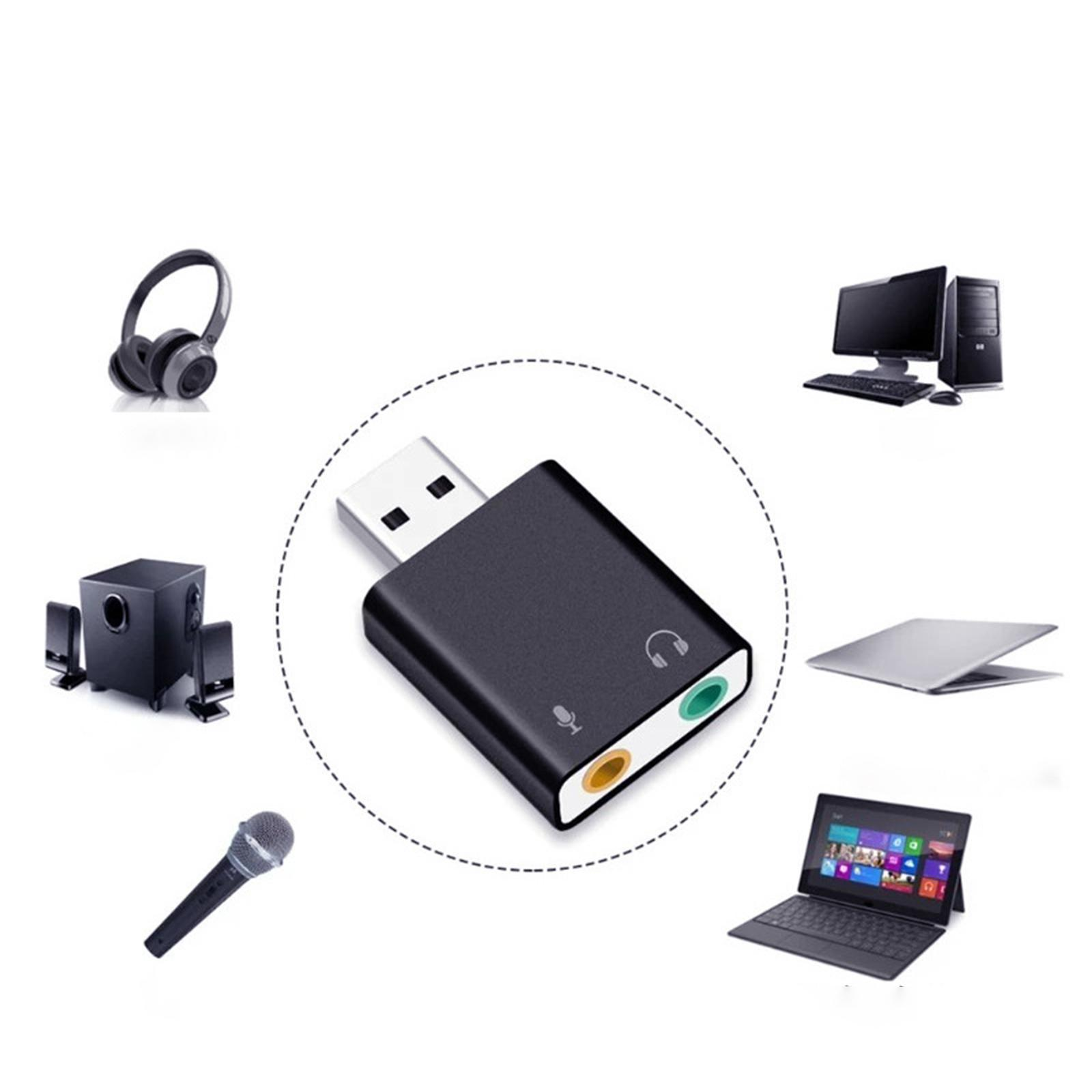 Ein weißer USB-Audioadapter, umgeben von Kopfhörern, einem Mikrofon und Computern.