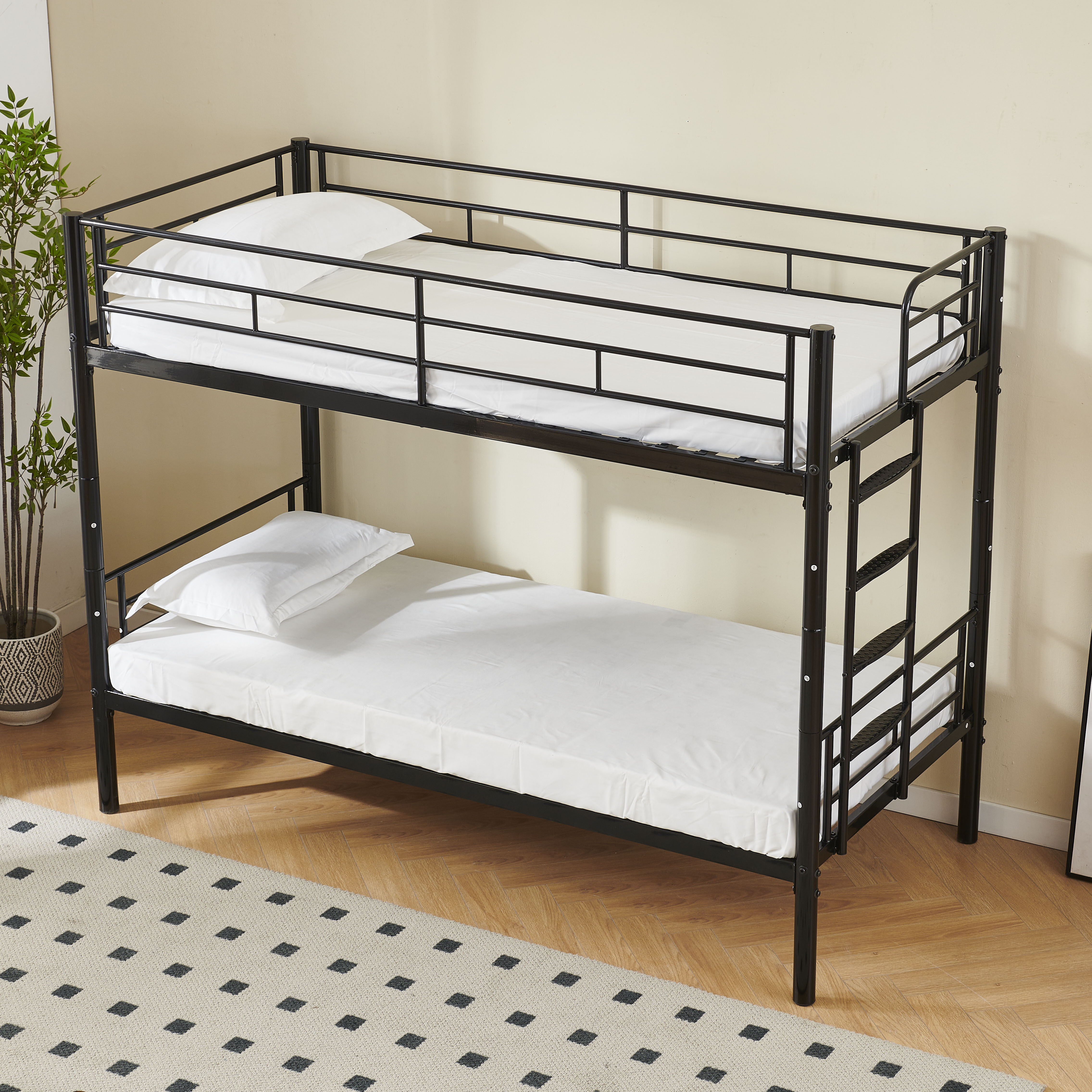 Ein schwarzes Metall-Etagenbett mit weißer Bettwäsche. Der Rahmen ist sichtbar, das Bett ist leer.