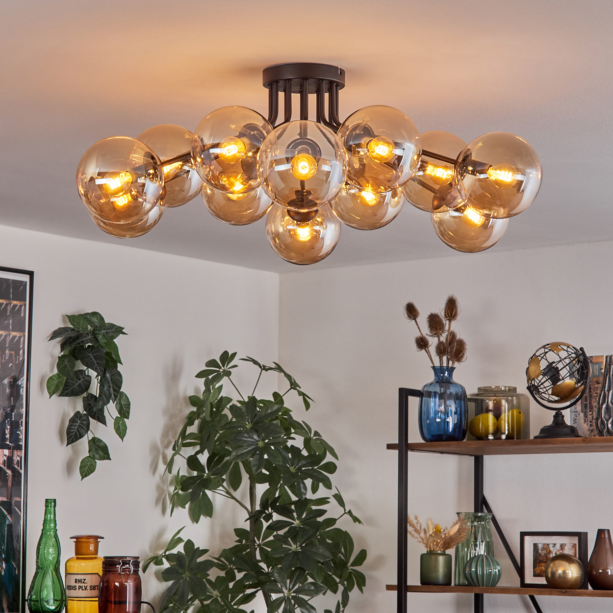 Eine Leuchte mit mehreren Glaskugellampen hängt von der Decke und beleuchtet den Raum.