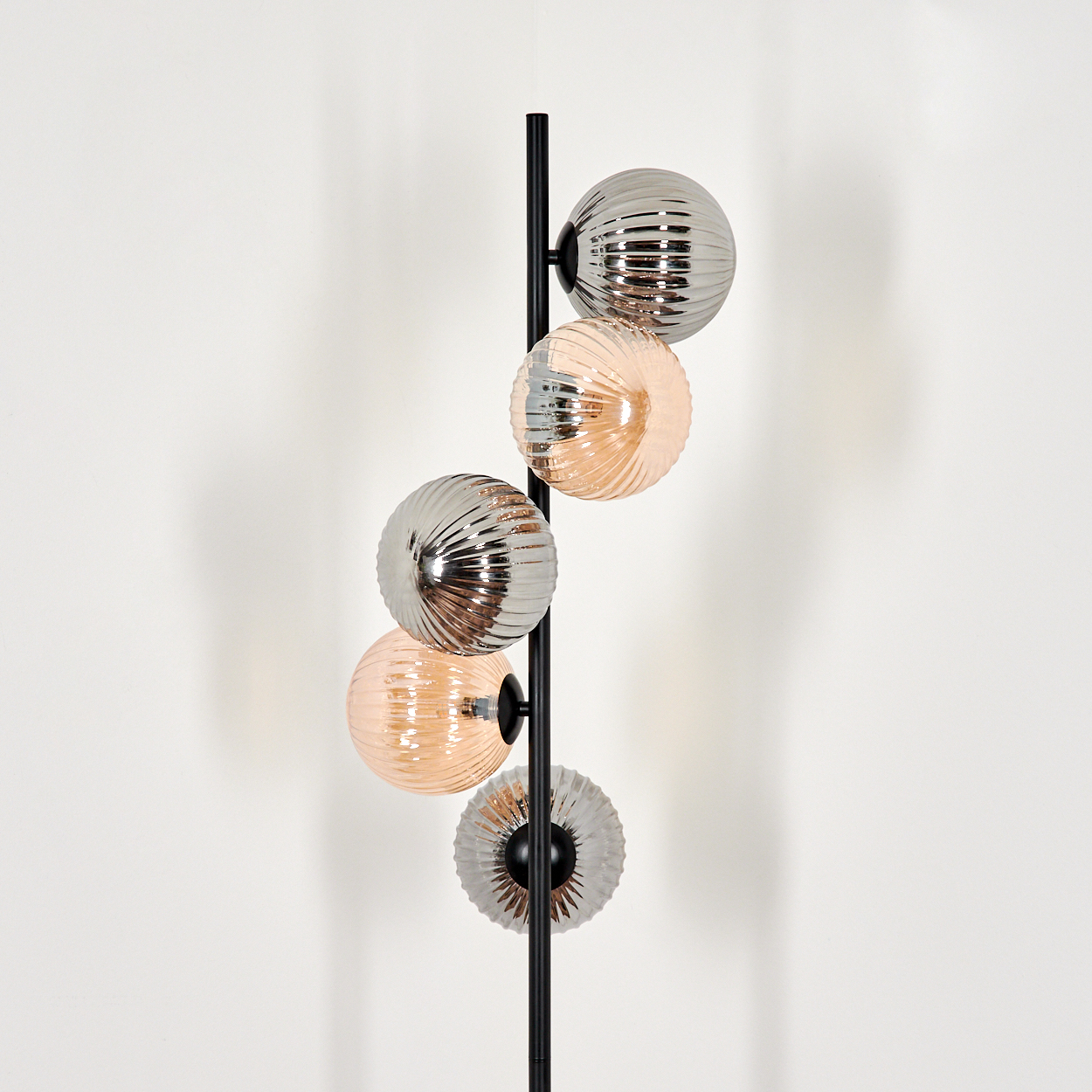 Stehlampe mit fünf Glaskugel-Schirmen, mit der Position der Lampe in einem Raum vor einer weißen Wand.