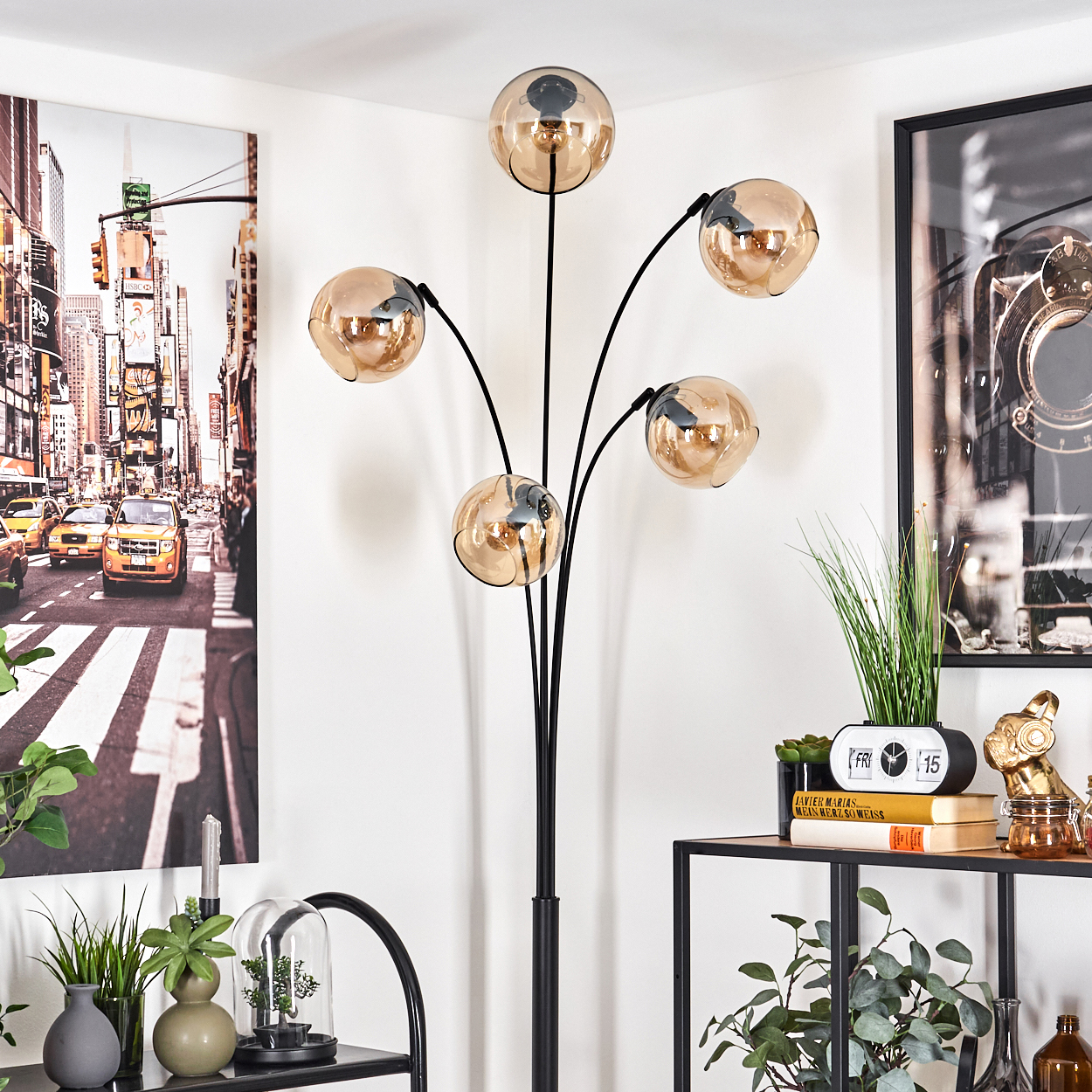 Lampe mit bernsteinfarbenen Glaskugeln, umgeben von Dekoration in einem Raum.